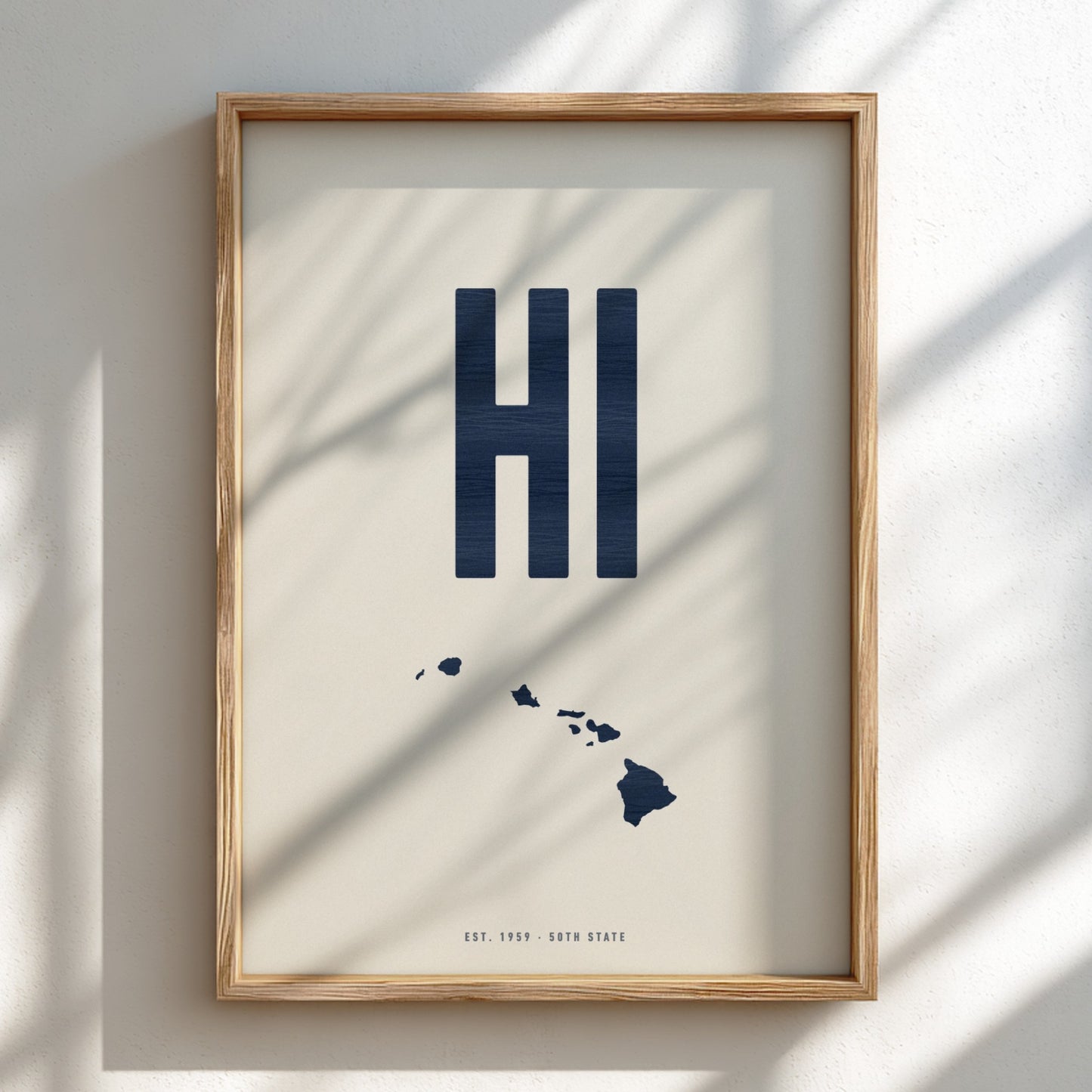 Framed artwork with 'HI' and a map of Hawaii on a light background