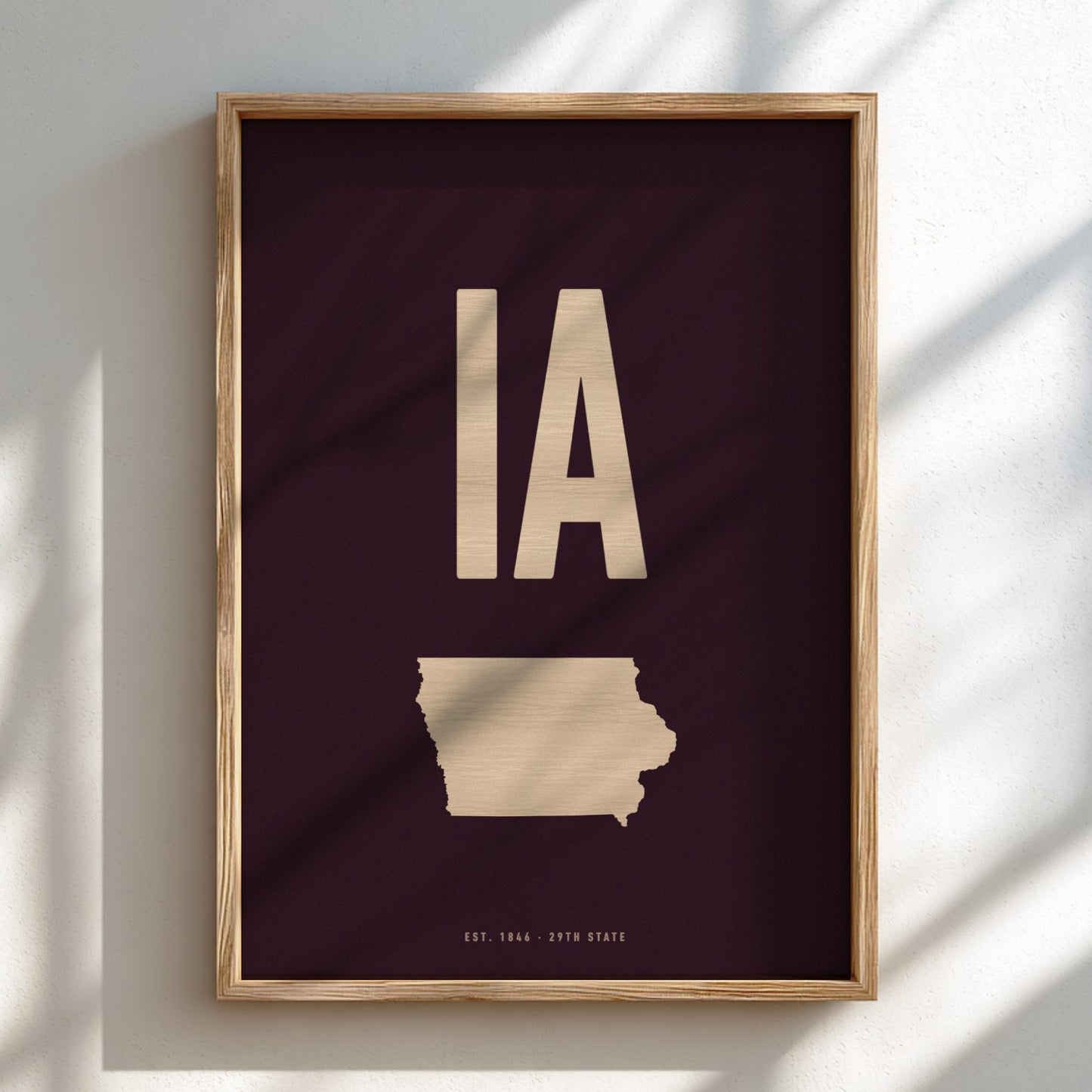 Framed artwork with 'IA' and outline of Iowa on a dark background