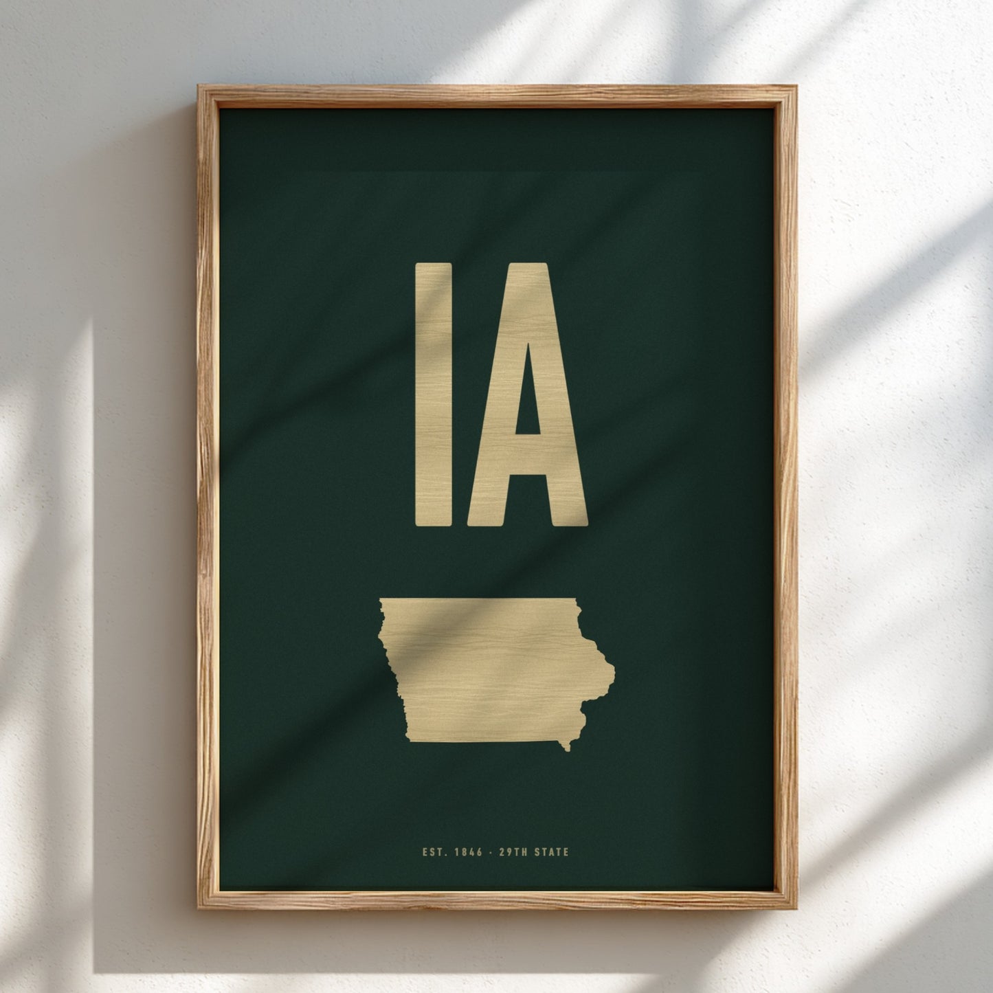 Framed artwork with gold state outline and 'IA' on a dark green background