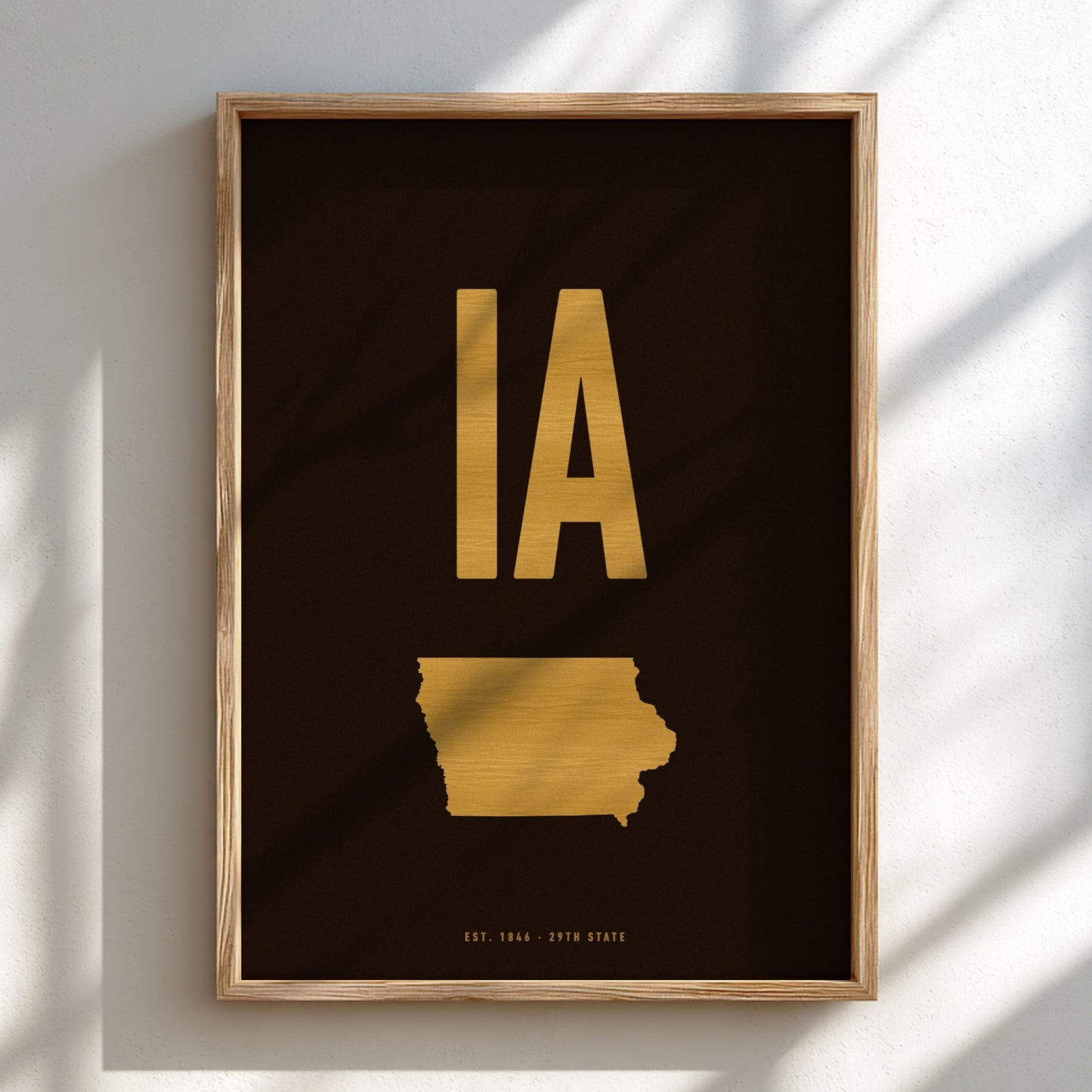 Framed artwork with gold state outline and 'IA' on a black background