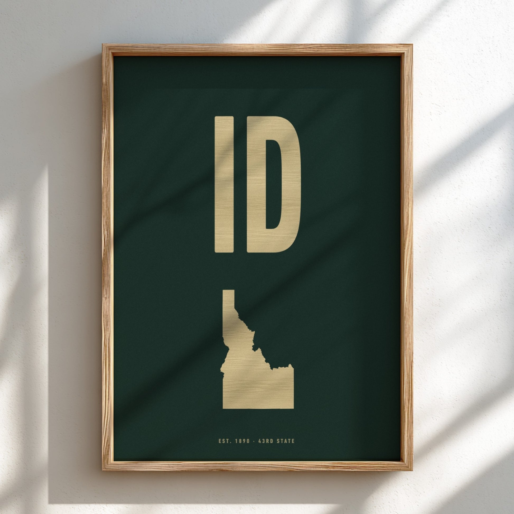 Framed artwork with gold 'ID' and Idaho outline on a dark green background