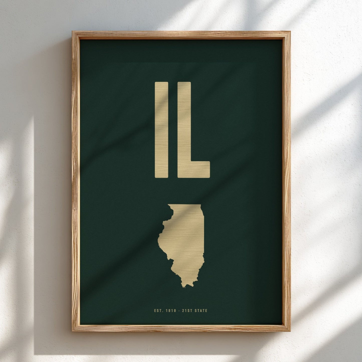 Framed artwork of the state of Illinois with 'IL' in gold on a dark green background.