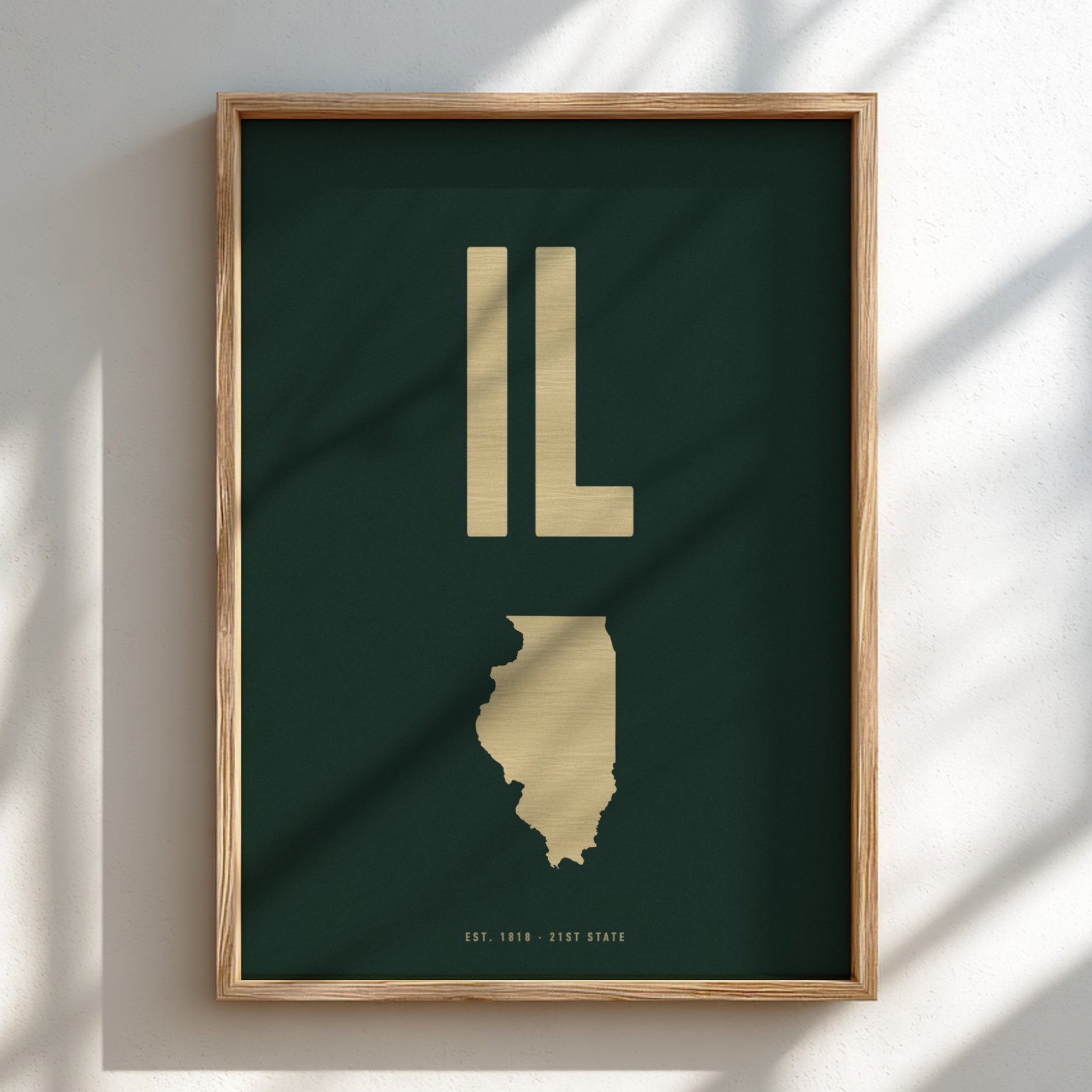Framed artwork of the state of Illinois with 'IL' in gold on a dark green background.