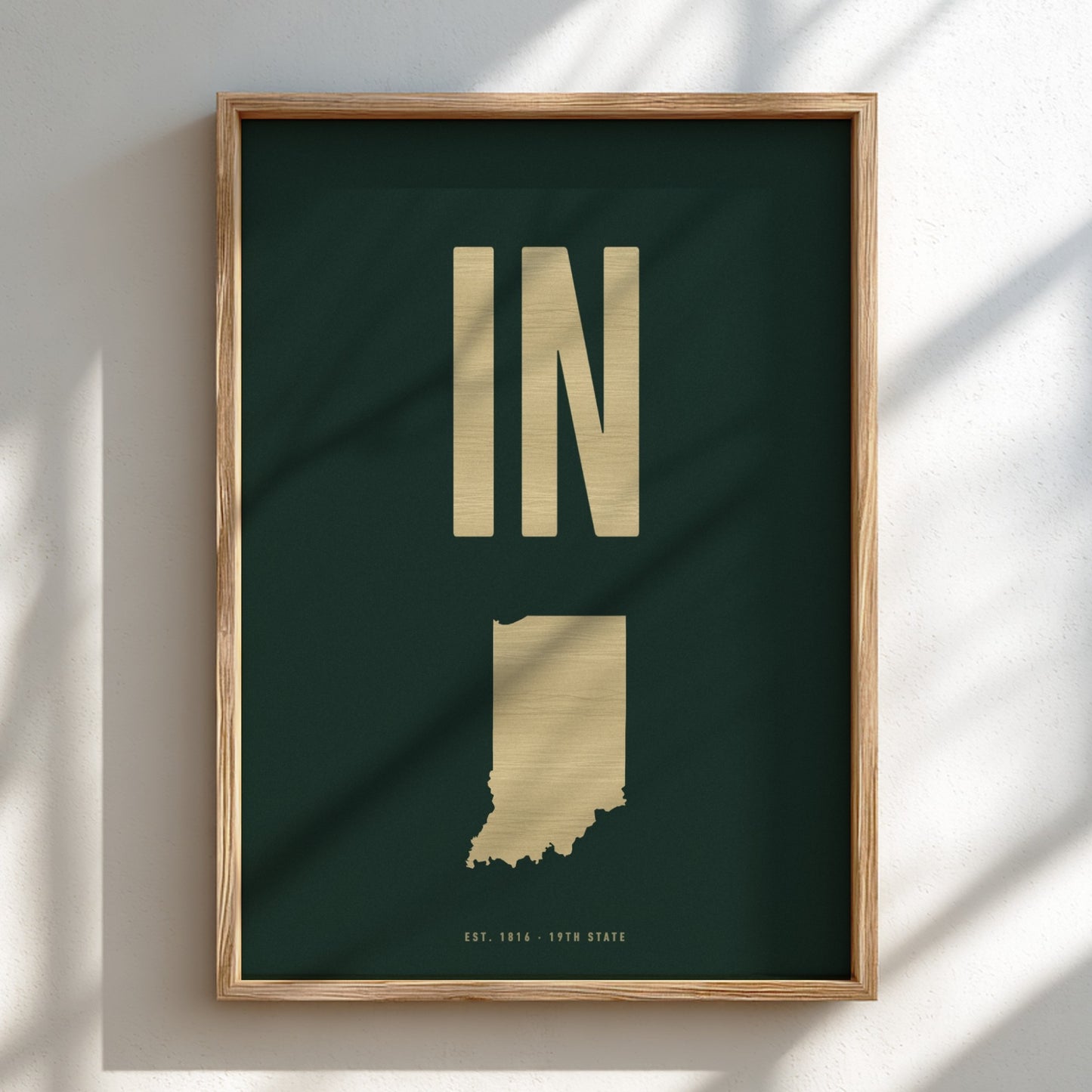 Framed artwork with a map of Indiana and the abbreviation 'IN' on a dark green background.