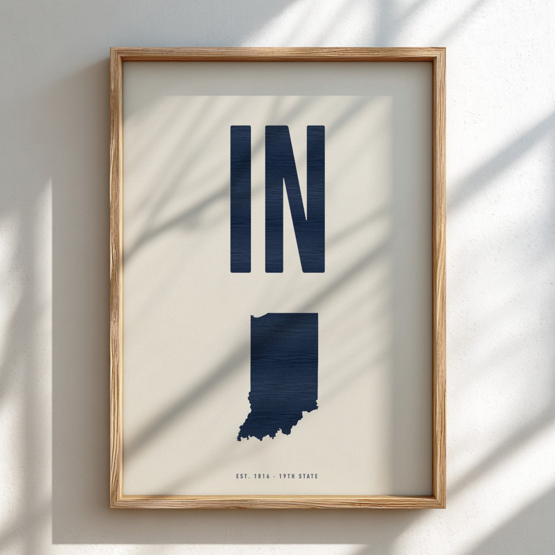 Framed artwork of the state of Indiana with 'IN' on a light background