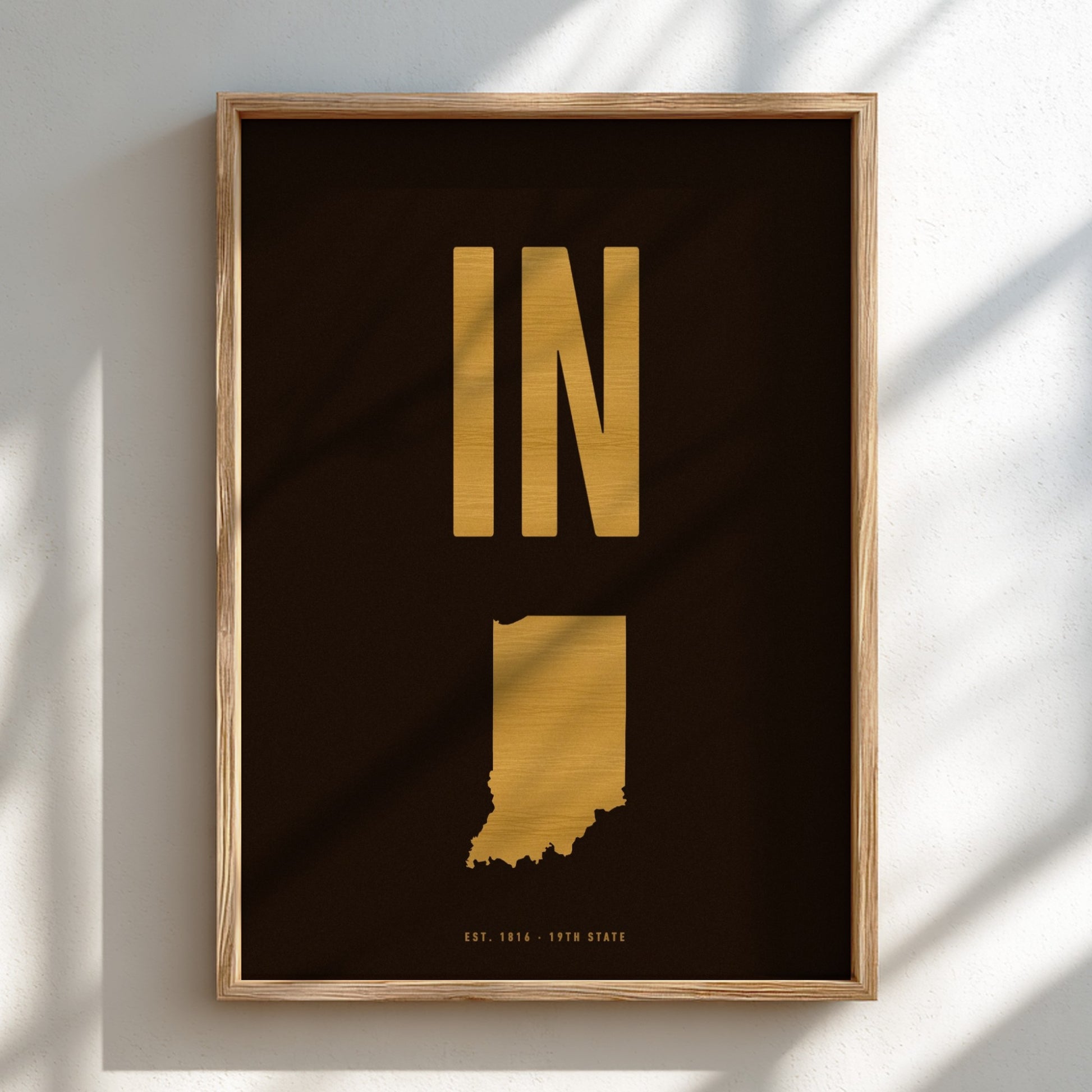 Framed artwork with gold state outline and 'IN' on a black background