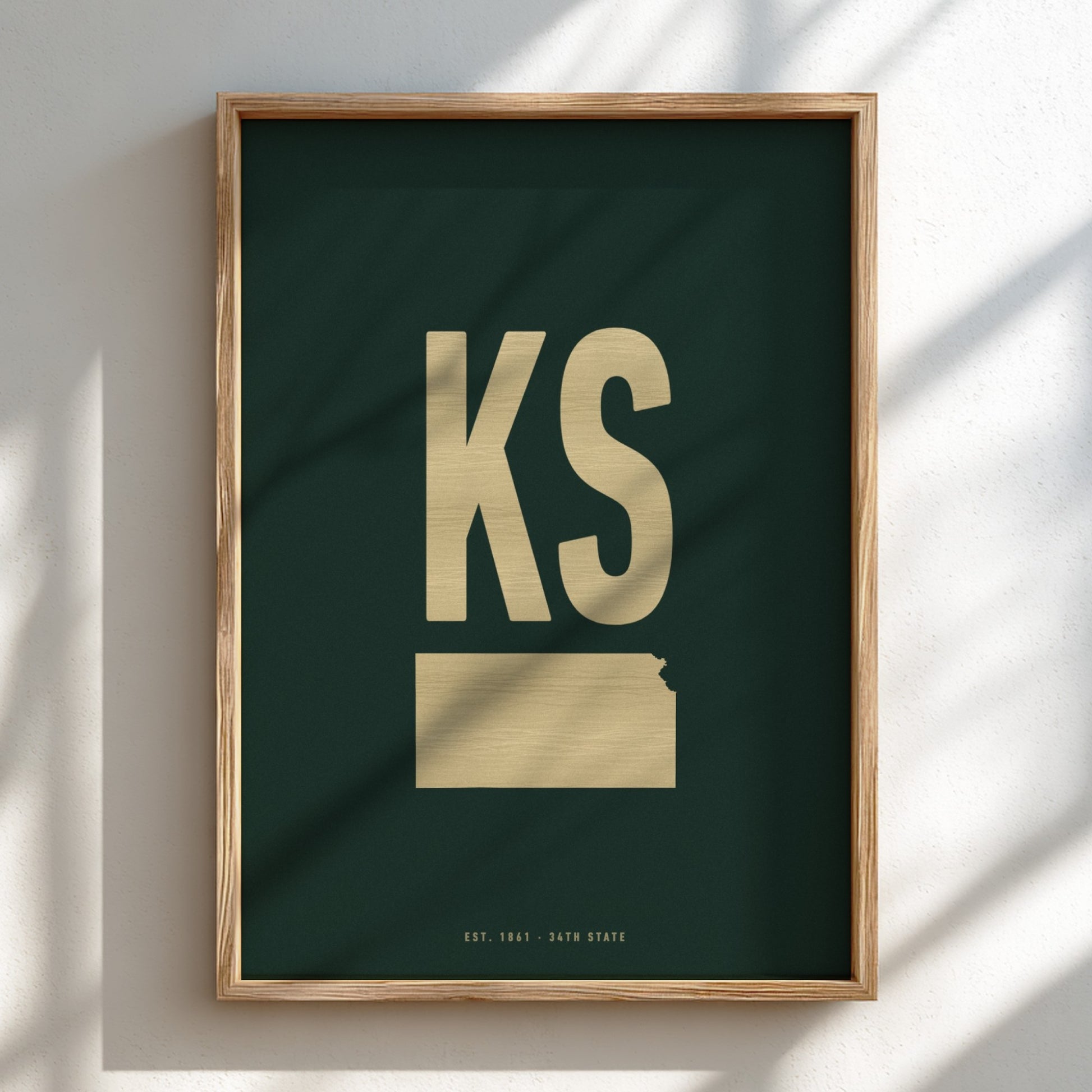 Framed artwork with 'KS' in gold on a dark green background