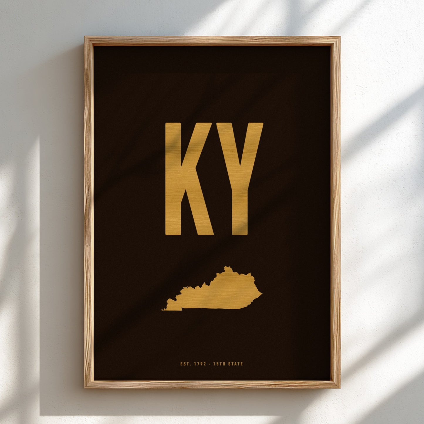 Framed poster with 'KY' in gold on a dark background