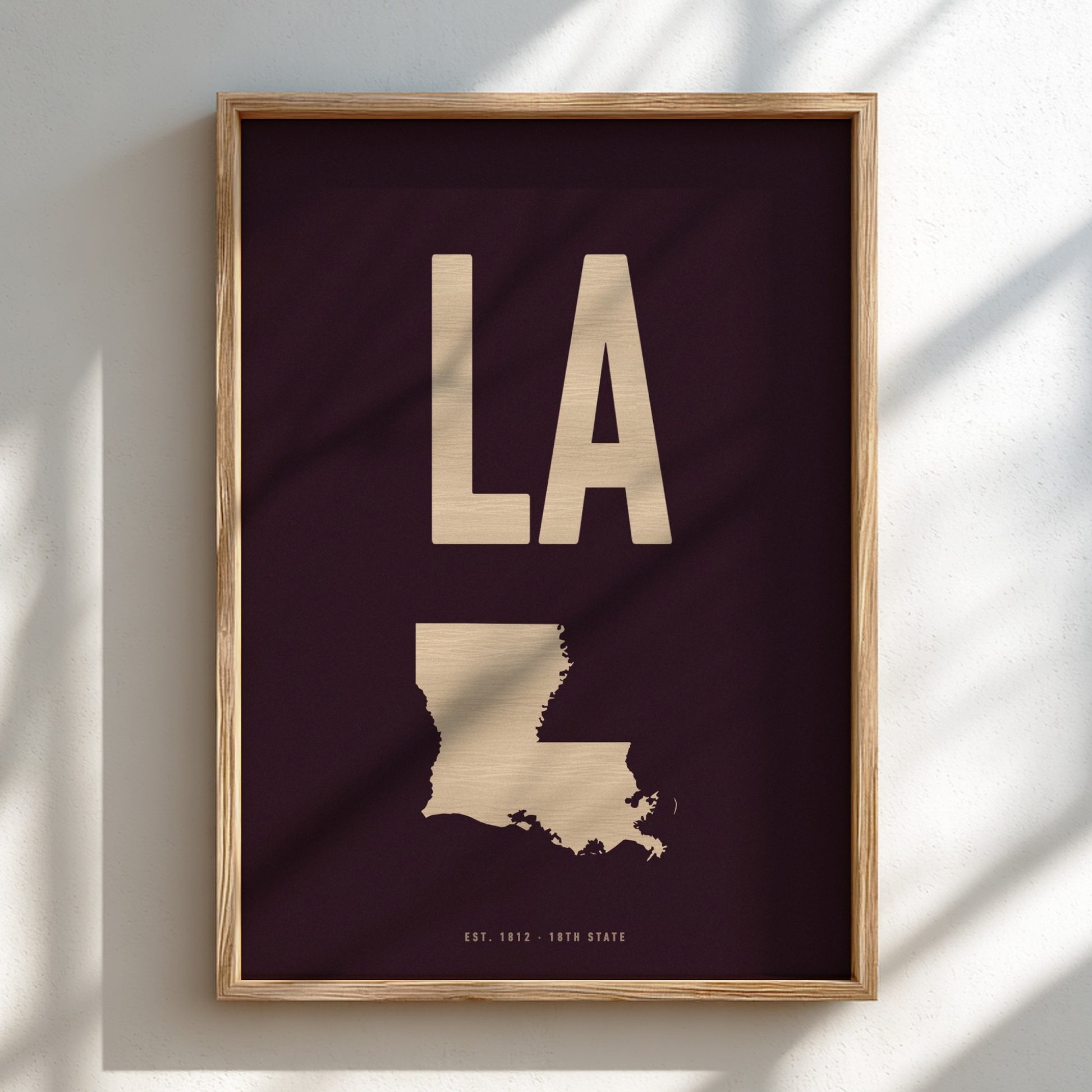 Framed artwork with 'LA' and outline of Louisiana on a dark background