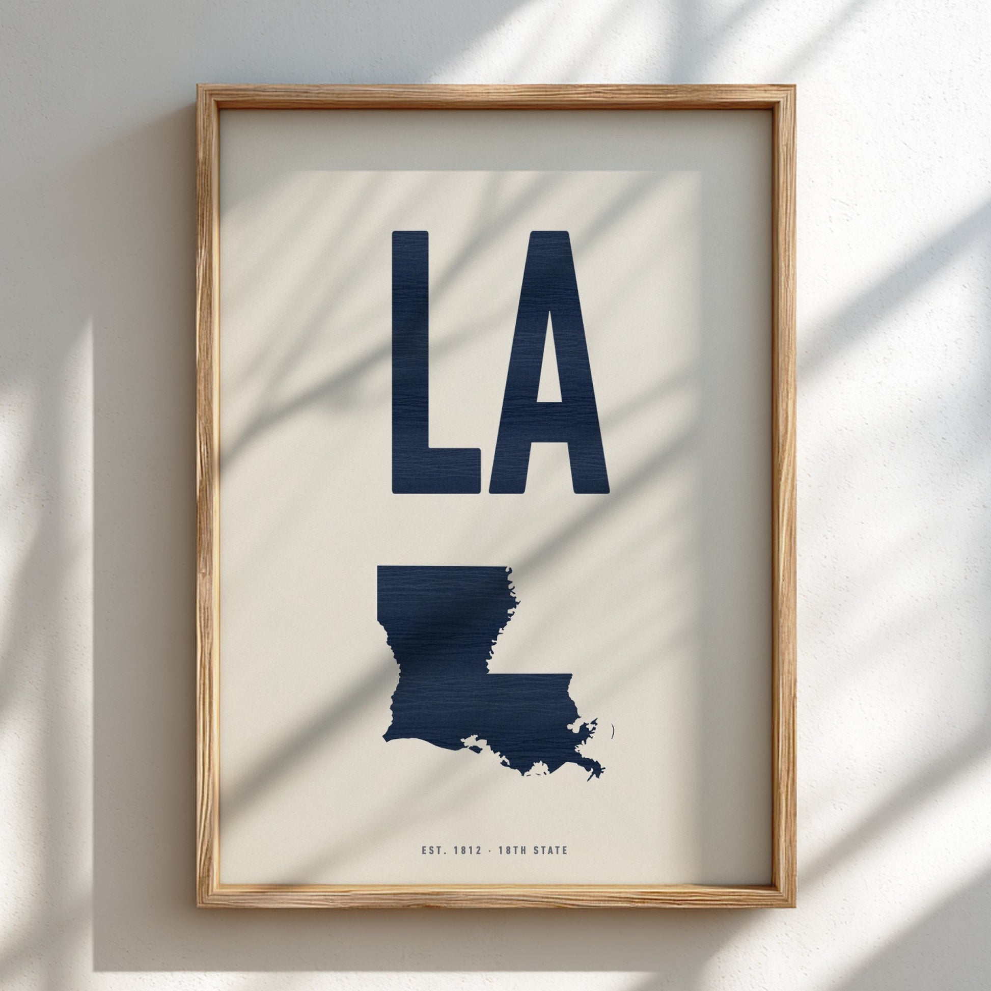 Framed artwork with 'LA' and a map of Louisiana on a light background