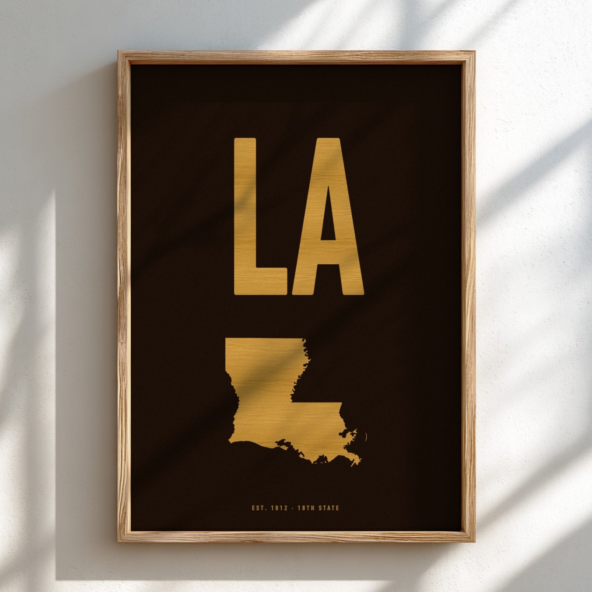 Framed artwork with 'LA' in gold on a black background