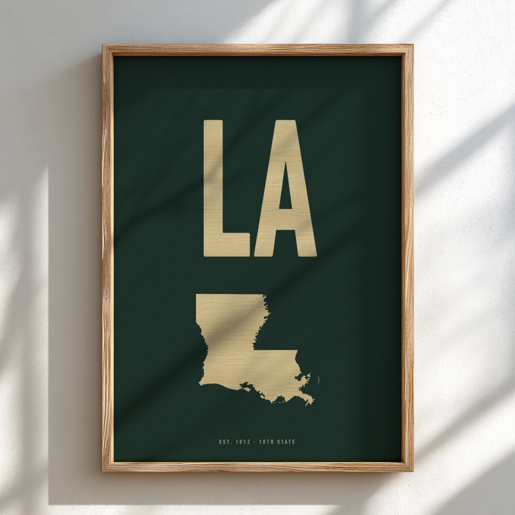Framed artwork with 'LA' in gold on a dark green background