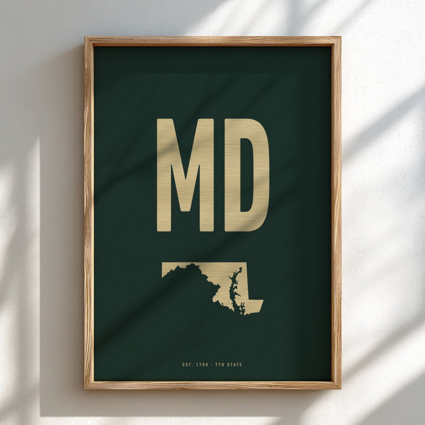Framed artwork with 'MD' in gold on a dark green background