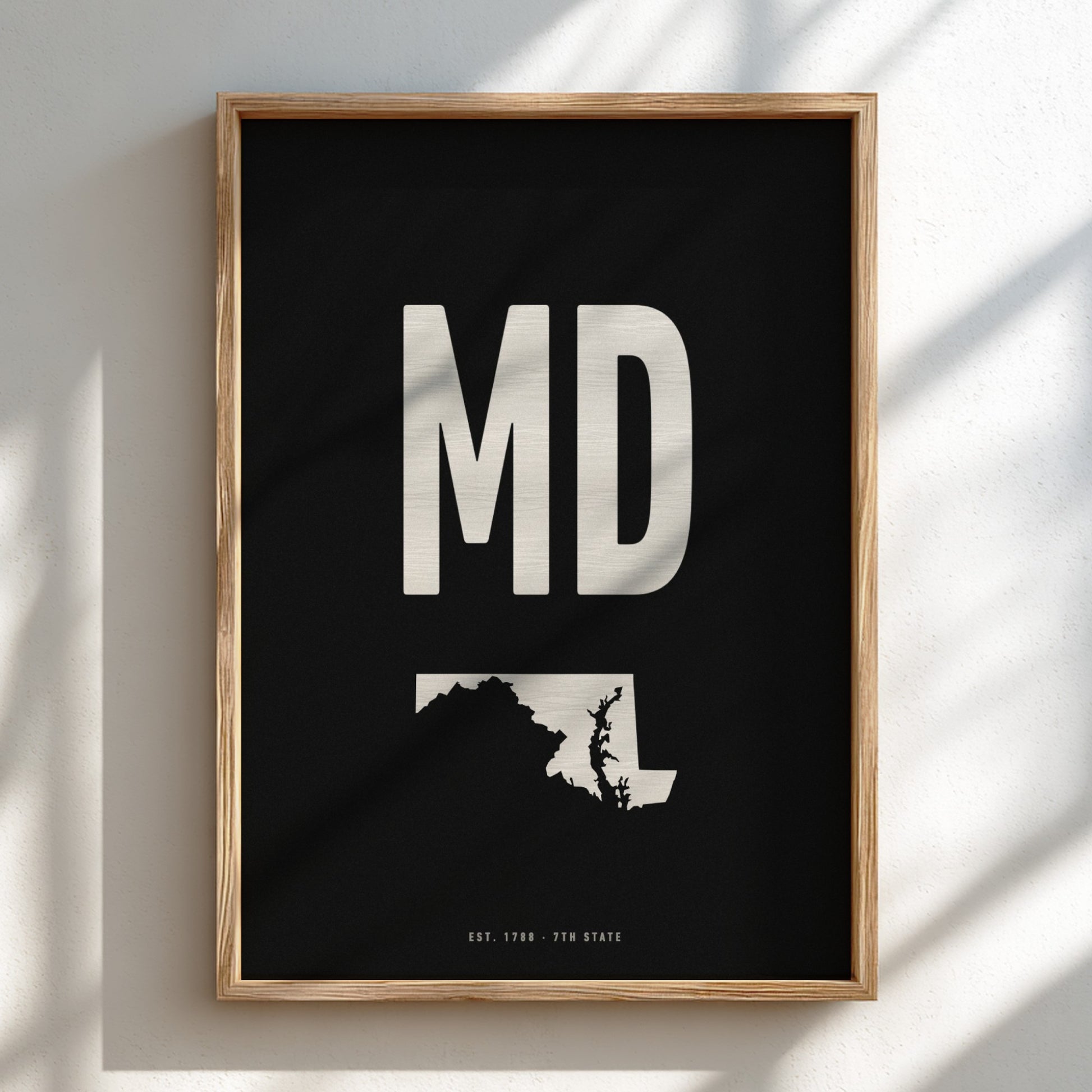 Framed poster with 'MD' and state outline on a black background