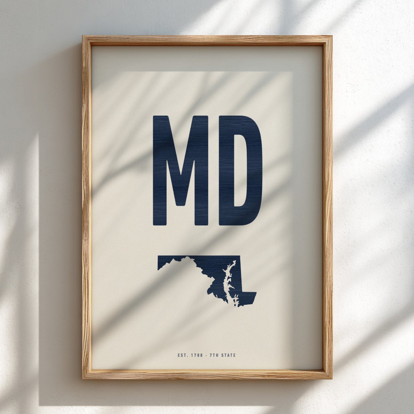 Framed artwork with 'MD' and a map of Maryland on a light background