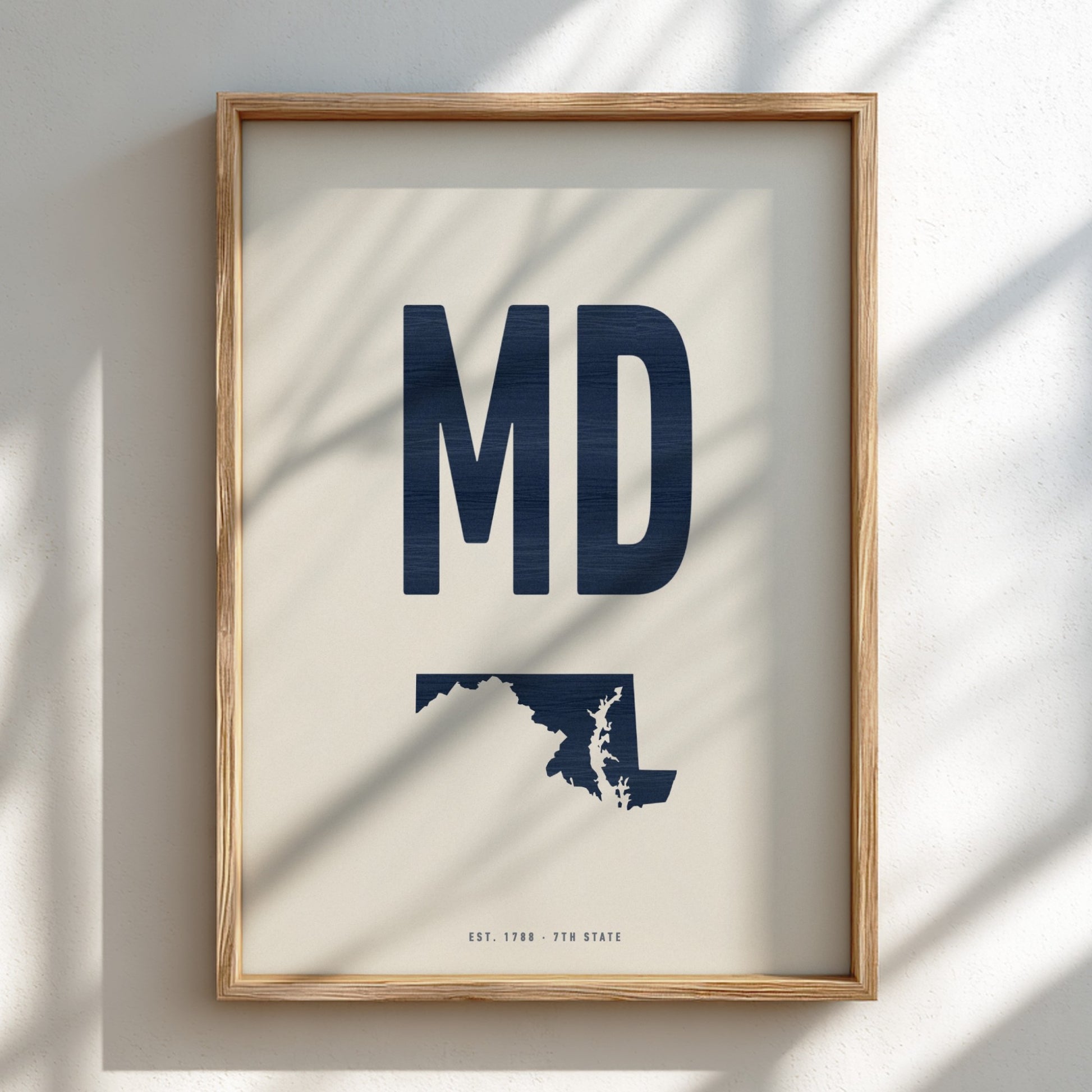Framed artwork with 'MD' and a map of Maryland on a light background
