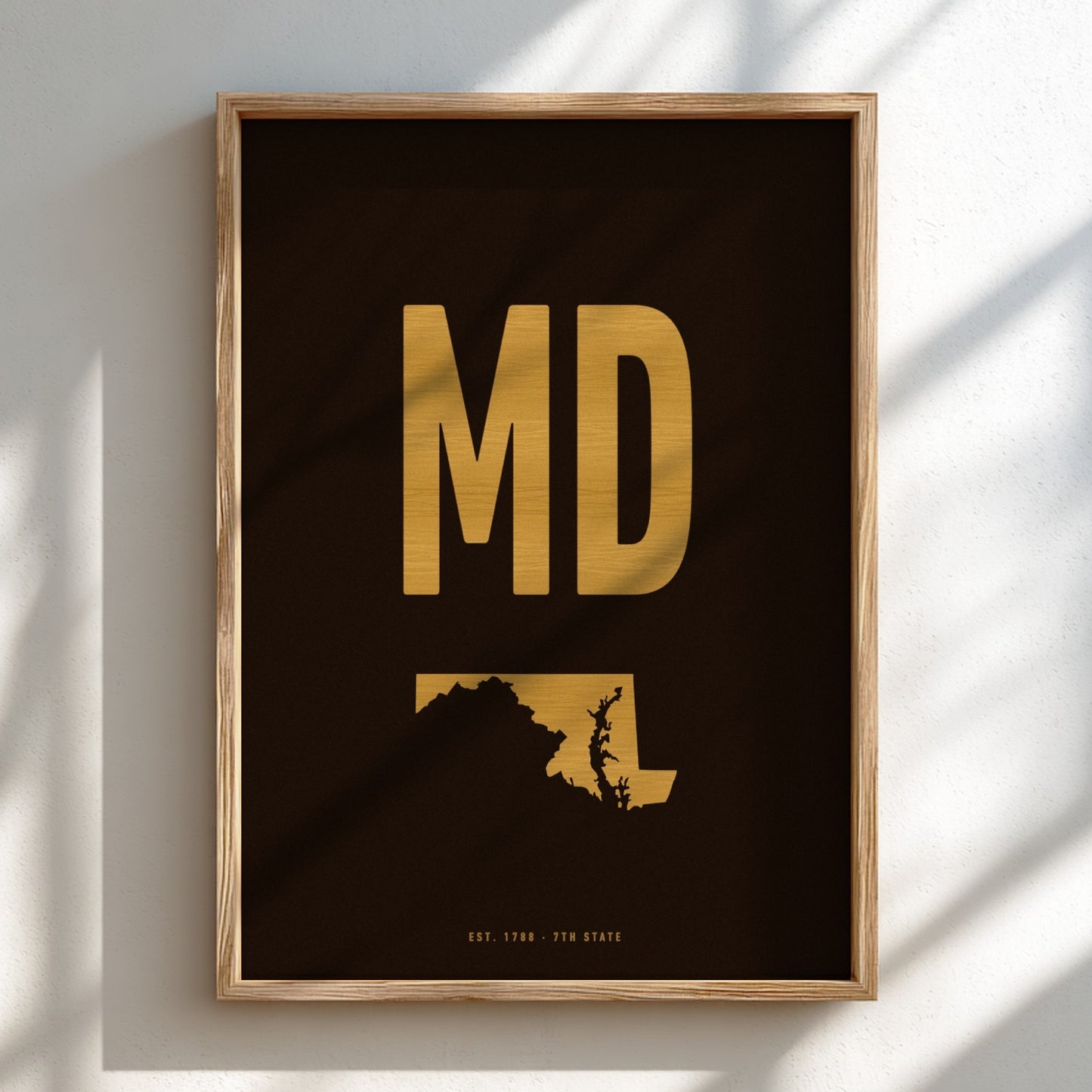Framed artwork with 'MD' in gold on a black background
