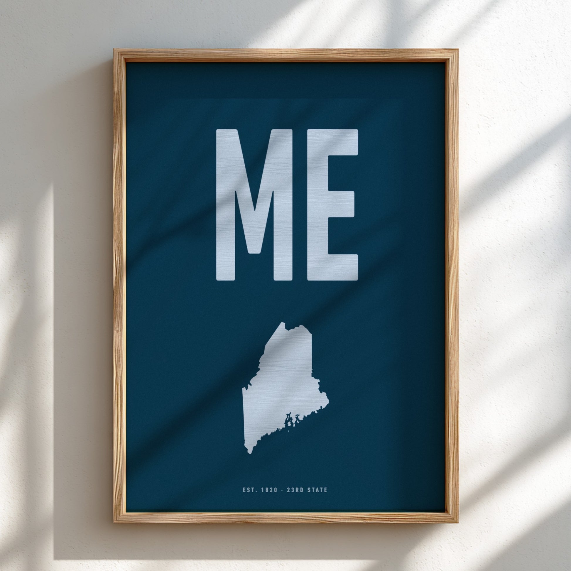 Framed poster with 'ME' and a map of Maine on a blue background