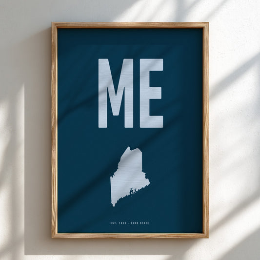 Framed poster with 'ME' and a map of Maine on a blue background