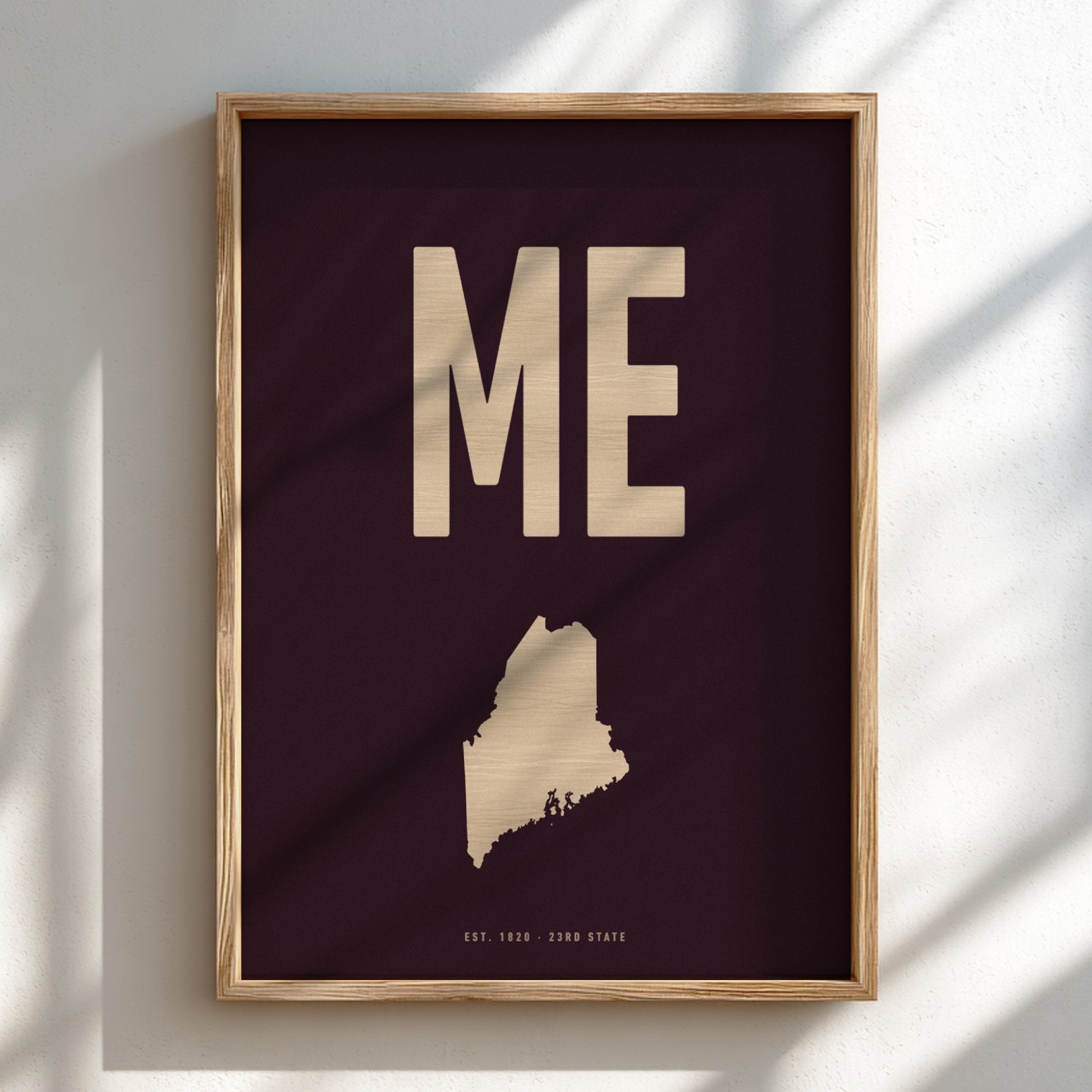 Framed artwork with 'ME' and a map of Maine on a dark background