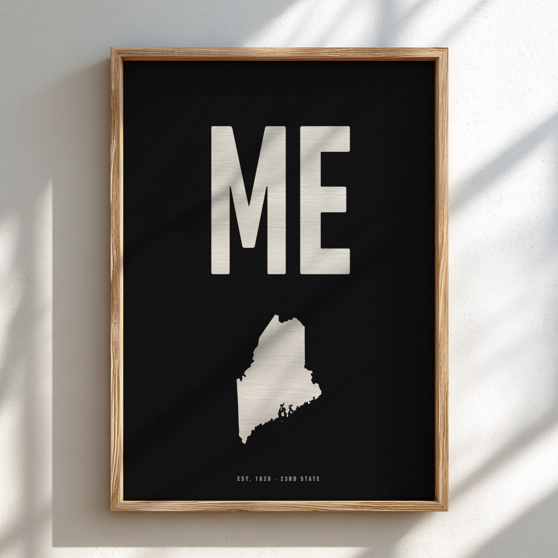 Framed poster with 'ME' and a map of Maine on a black background