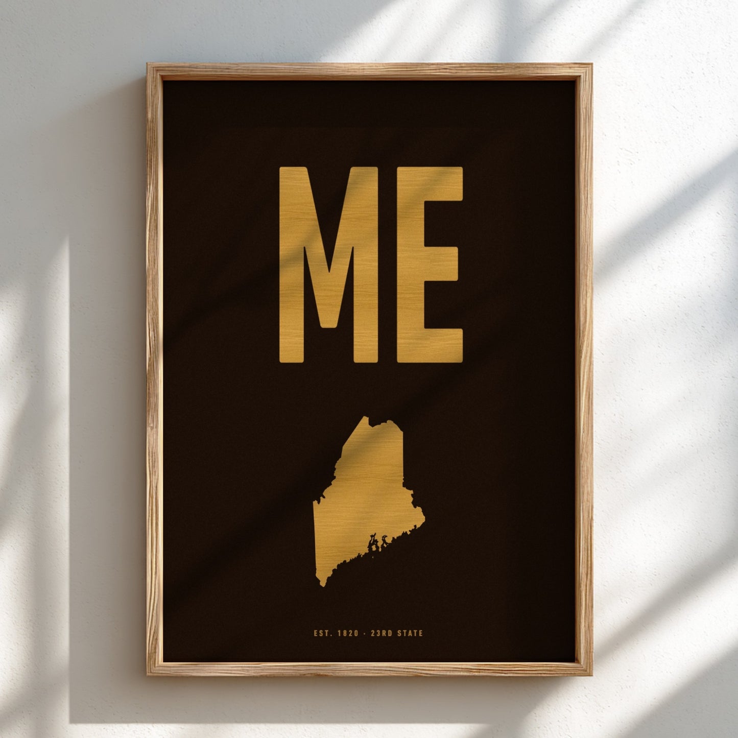 Framed artwork with 'ME' in gold on a dark background