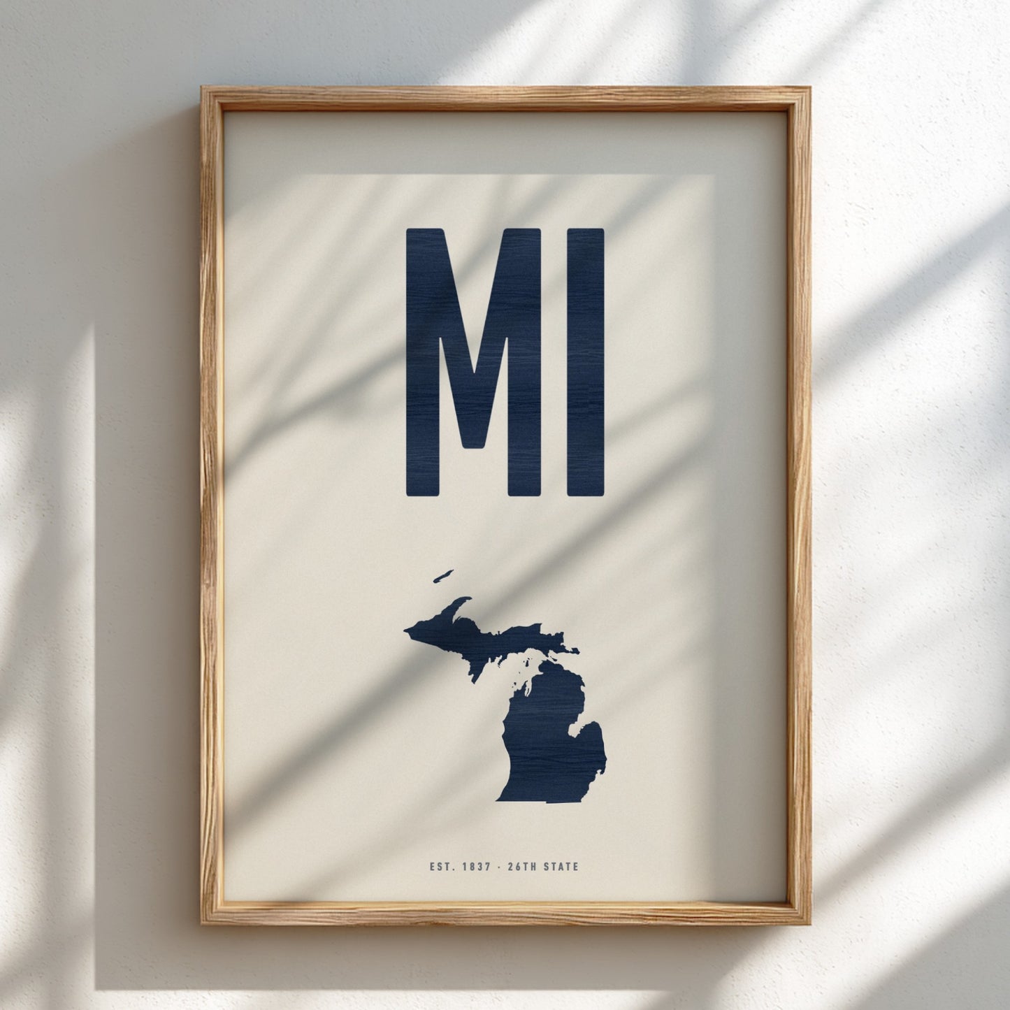Framed artwork with 'MI' and a map of Michigan on a light background