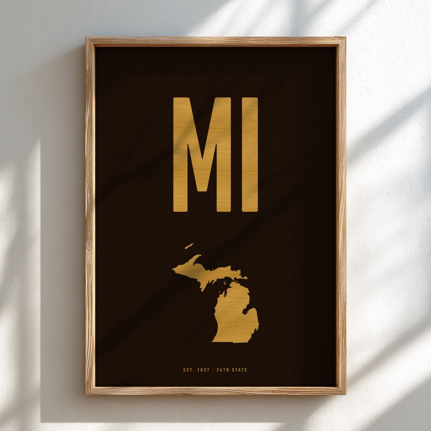 Framed artwork with gold 'MI' and map of Michigan on a black background