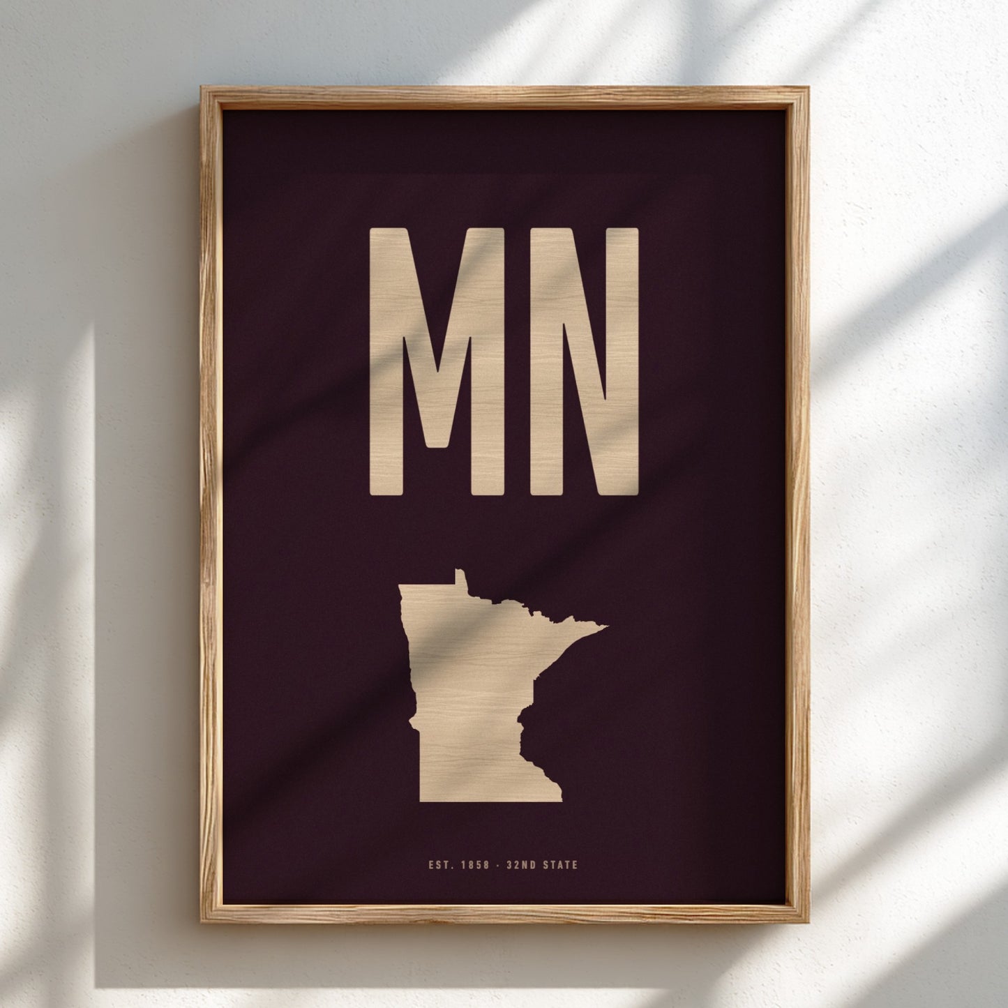 Framed artwork with 'MN' and outline of Minnesota on a dark background