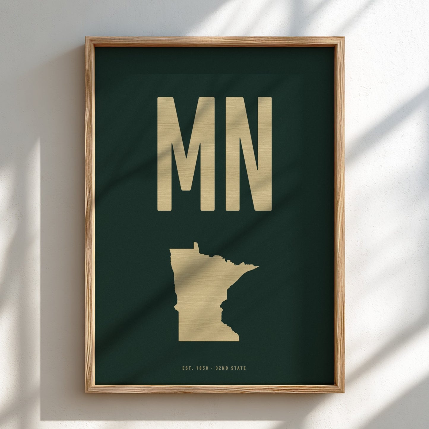 Framed artwork with 'MN' and a map of Minnesota on a dark green background