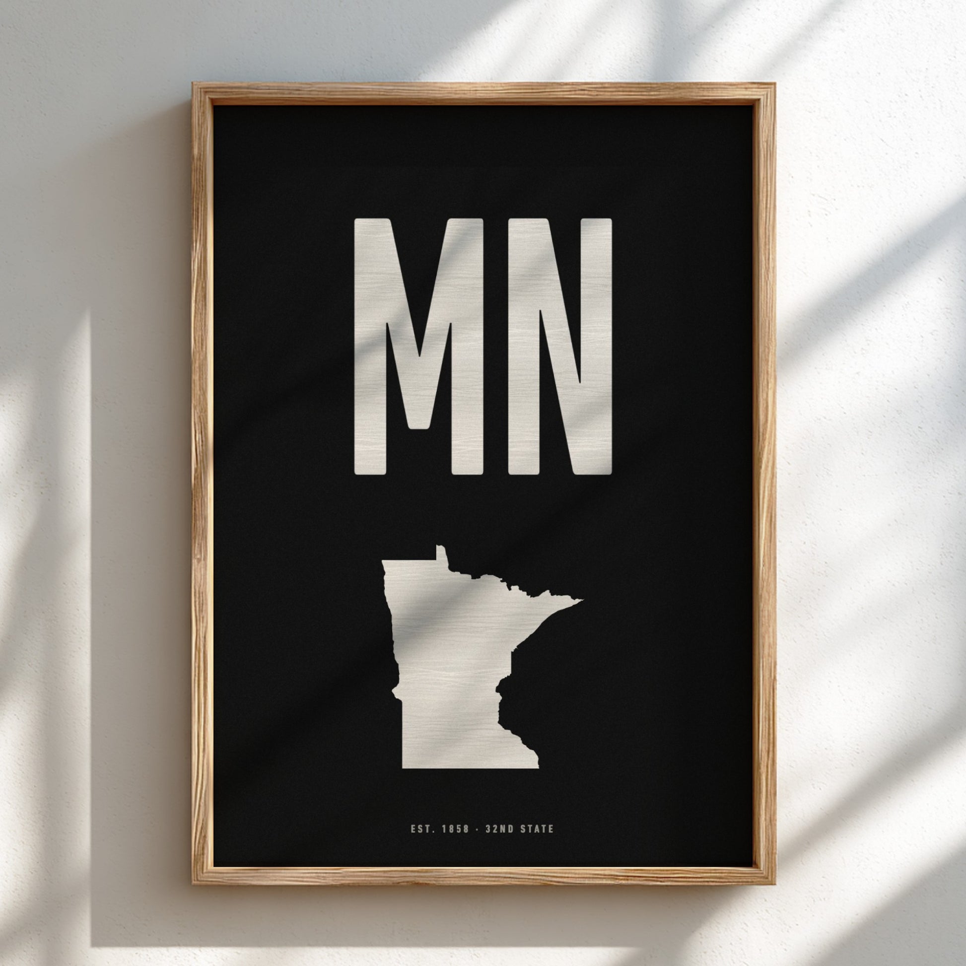 Framed artwork with 'MN' and outline of Minnesota on a black background
