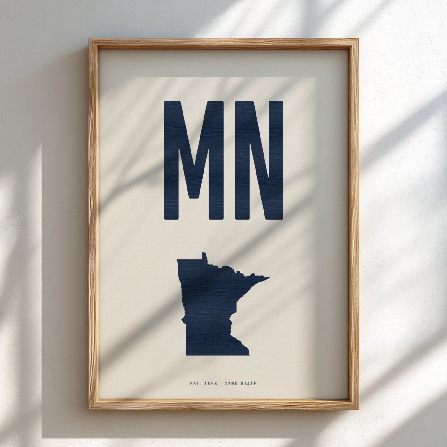 Framed artwork with 'MN' and a map of Minnesota on a light background
