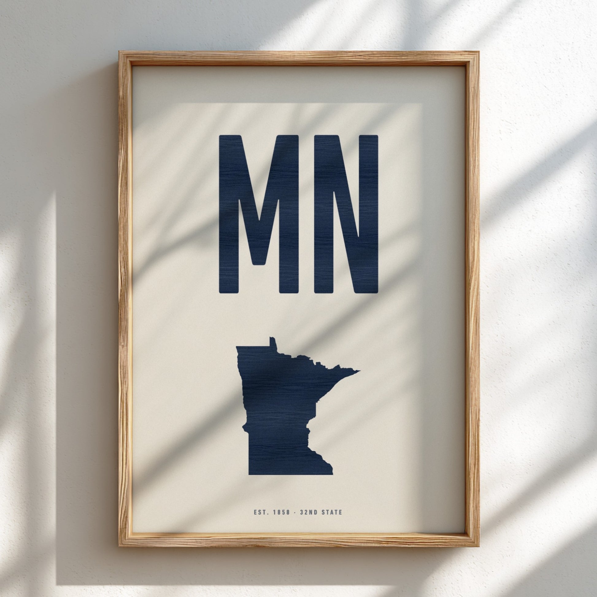 Framed artwork with 'MN' and a map of Minnesota on a light background