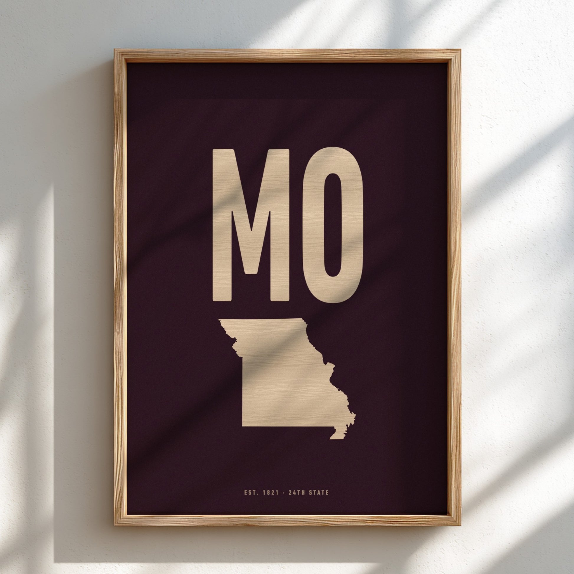 Framed artwork with 'MO' in gold on a dark background