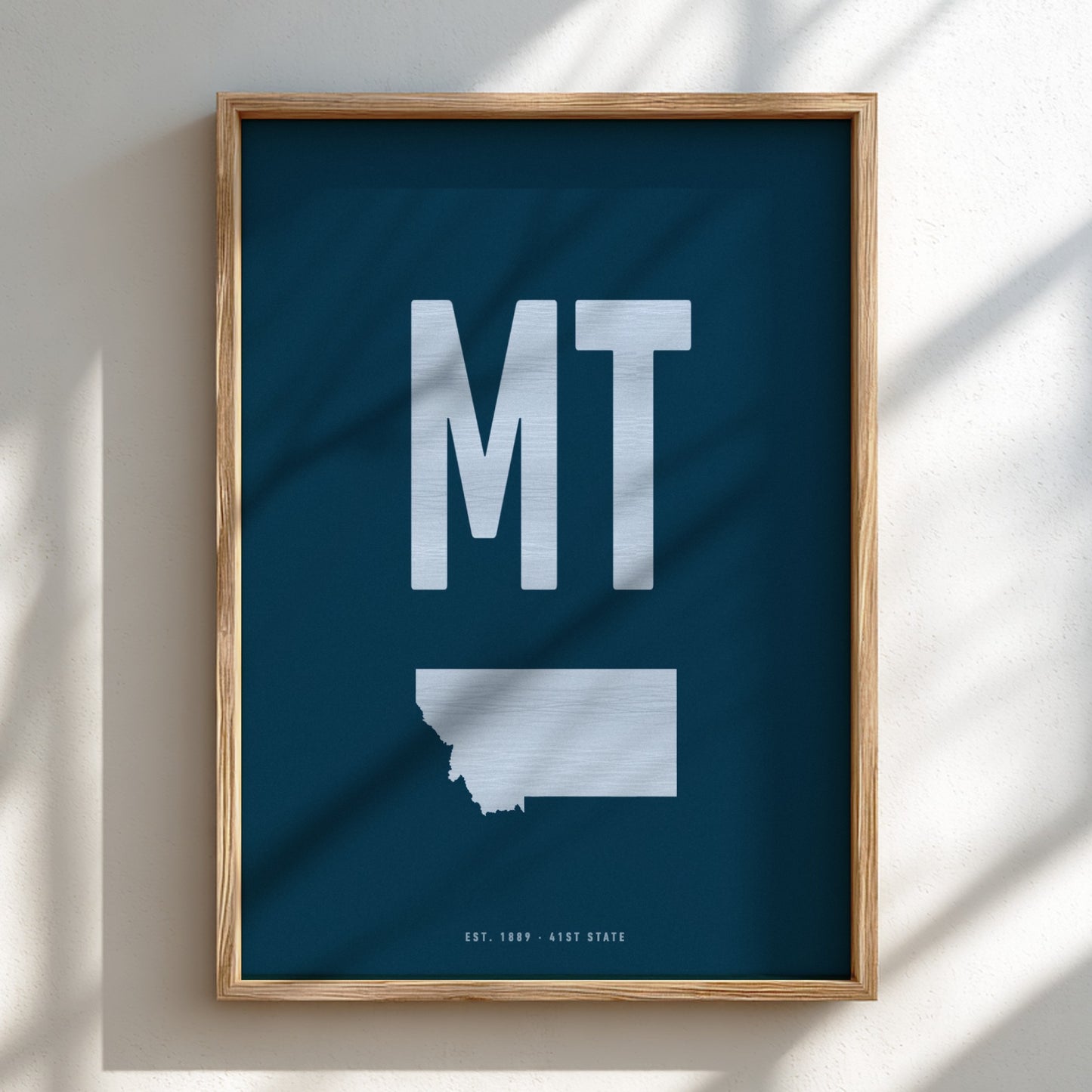 Framed poster with 'MT' and a map of Montana on a blue background