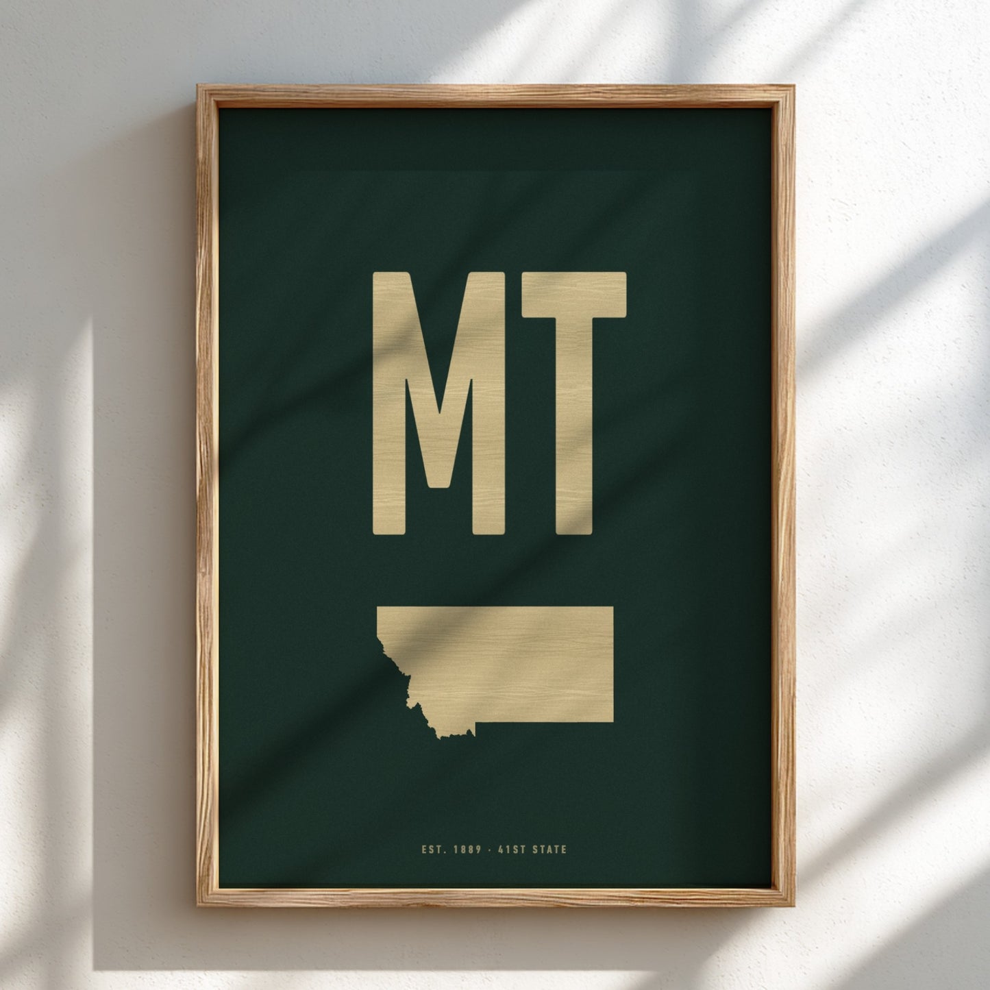 Framed artwork with 'MT' and a map of Montana on a dark green background