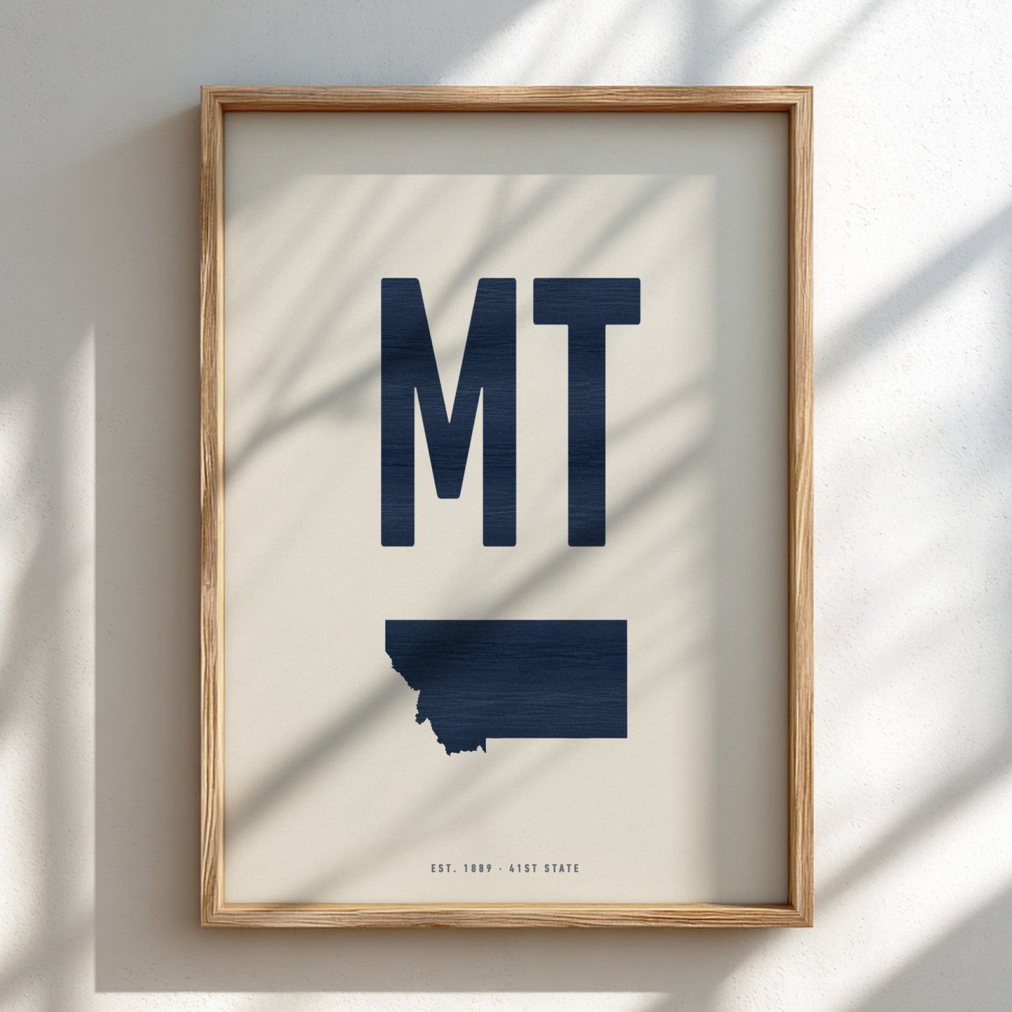 Framed artwork with 'MT' and a map of Montana on a light background