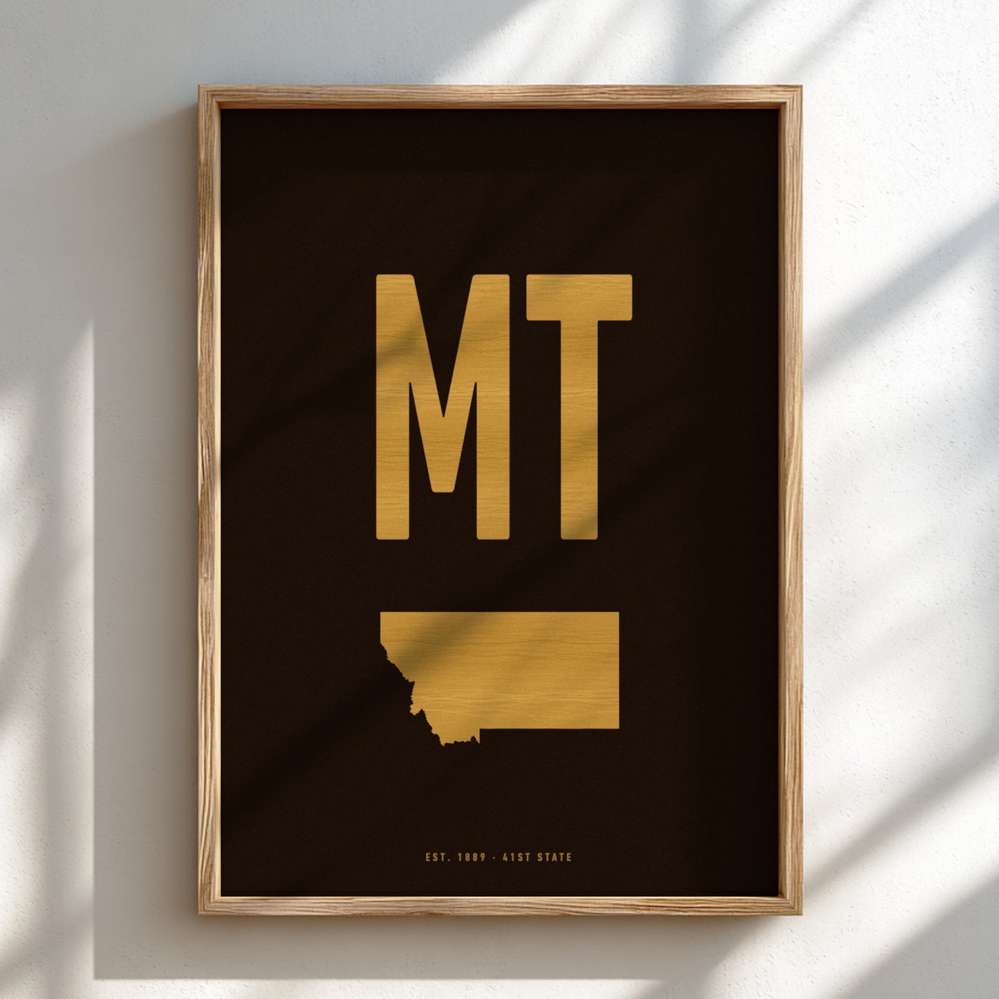 Framed artwork with 'MT' in gold on a black background