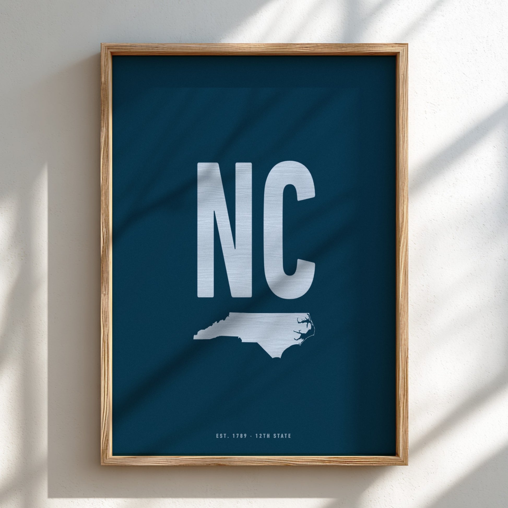 Framed poster with 'NC' and a map of North Carolina on a blue background