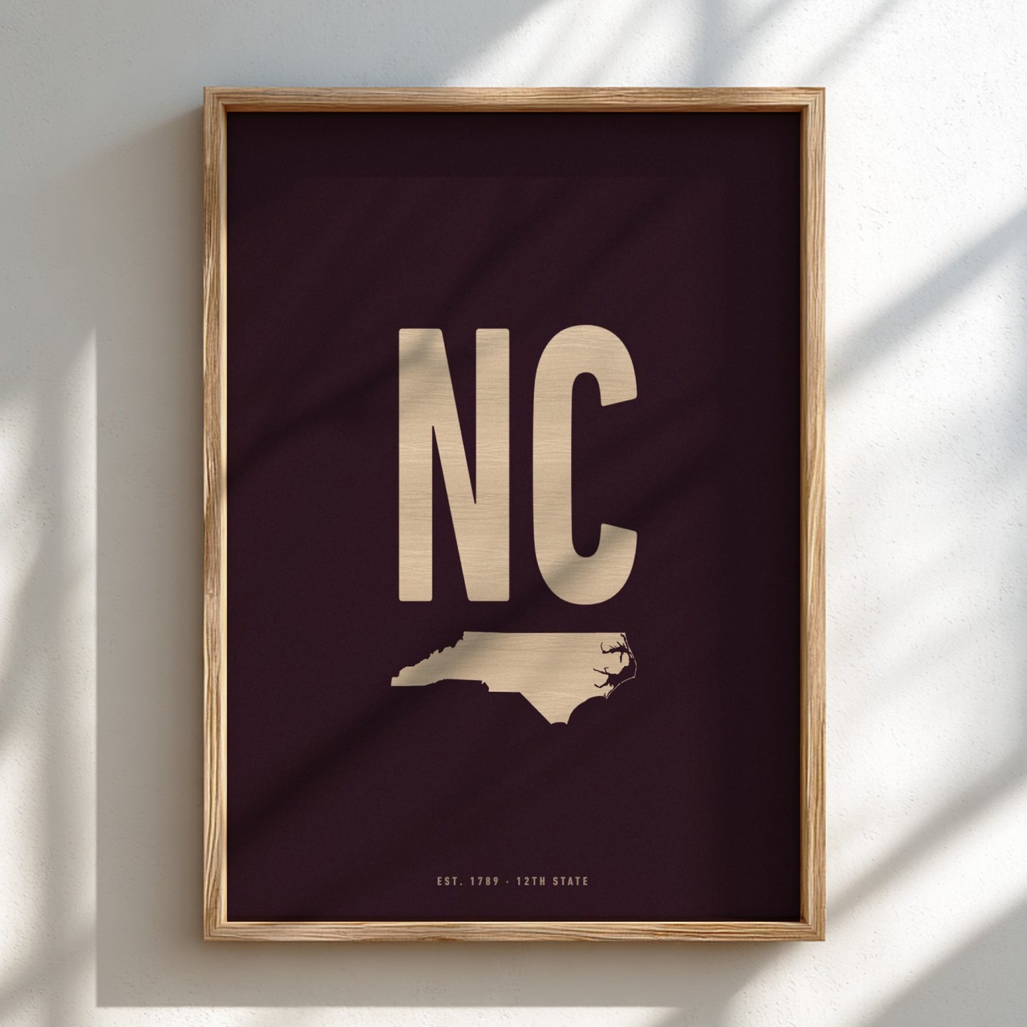 Framed artwork with 'NC' and a map of North Carolina on a dark background