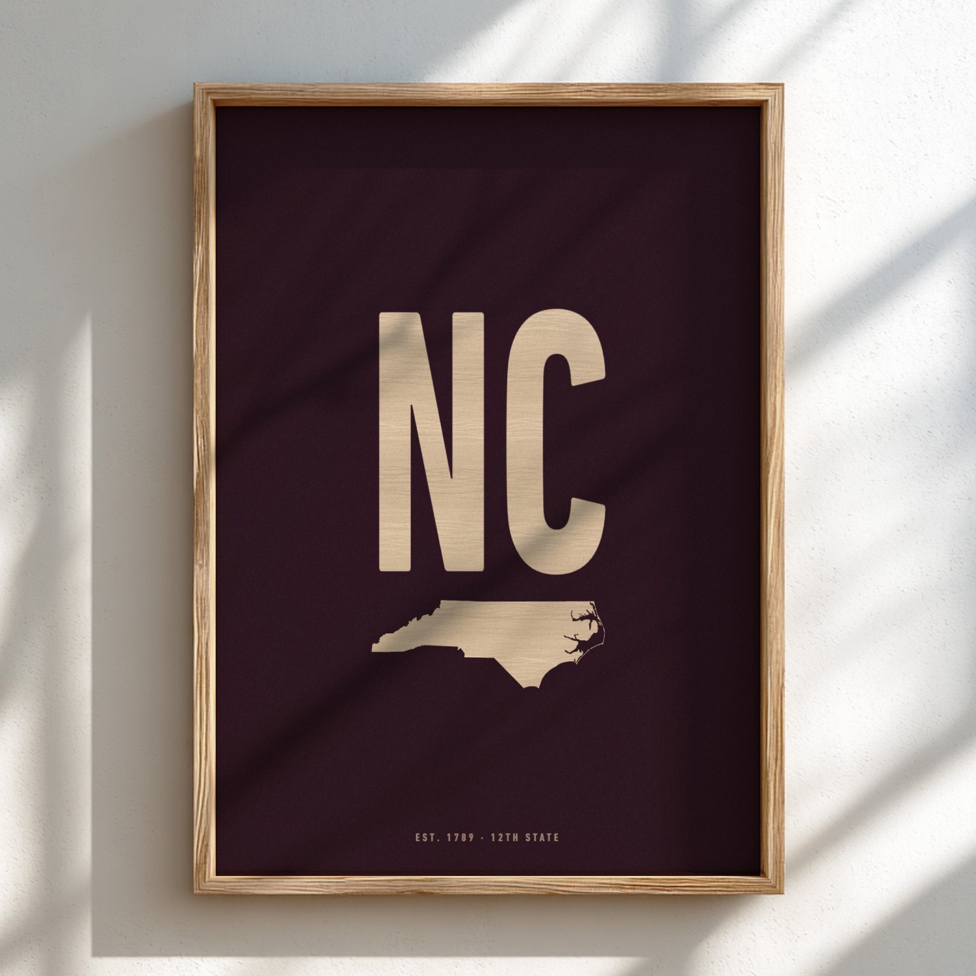 Framed artwork with 'NC' and a map of North Carolina on a dark background