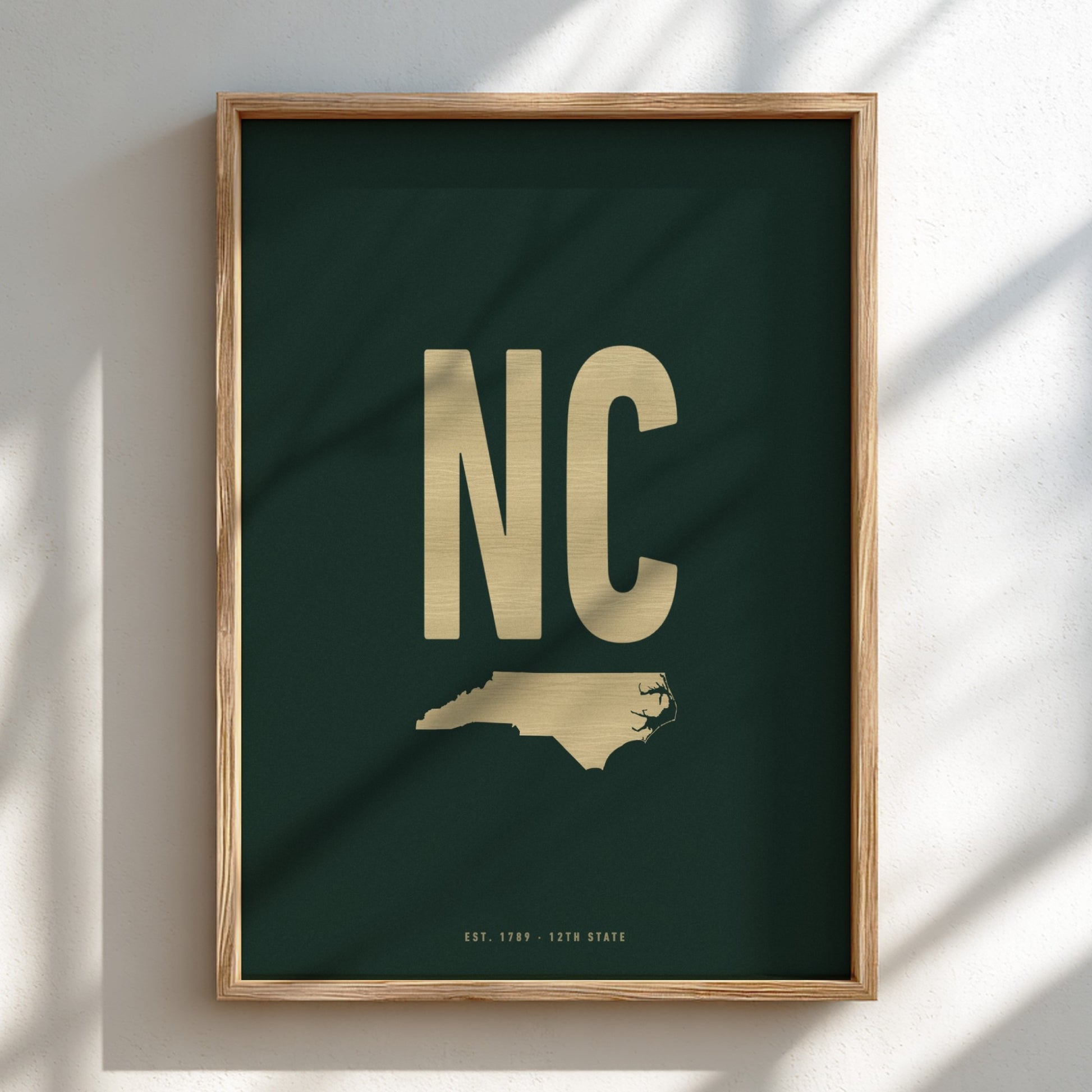 Framed artwork with 'NC' in gold on a dark green background