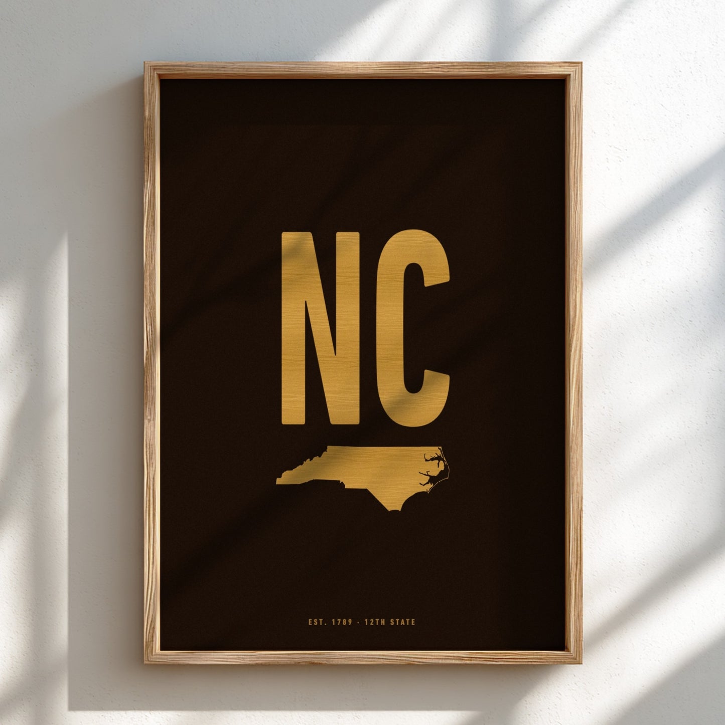 Framed artwork with 'NC' in gold on a black background