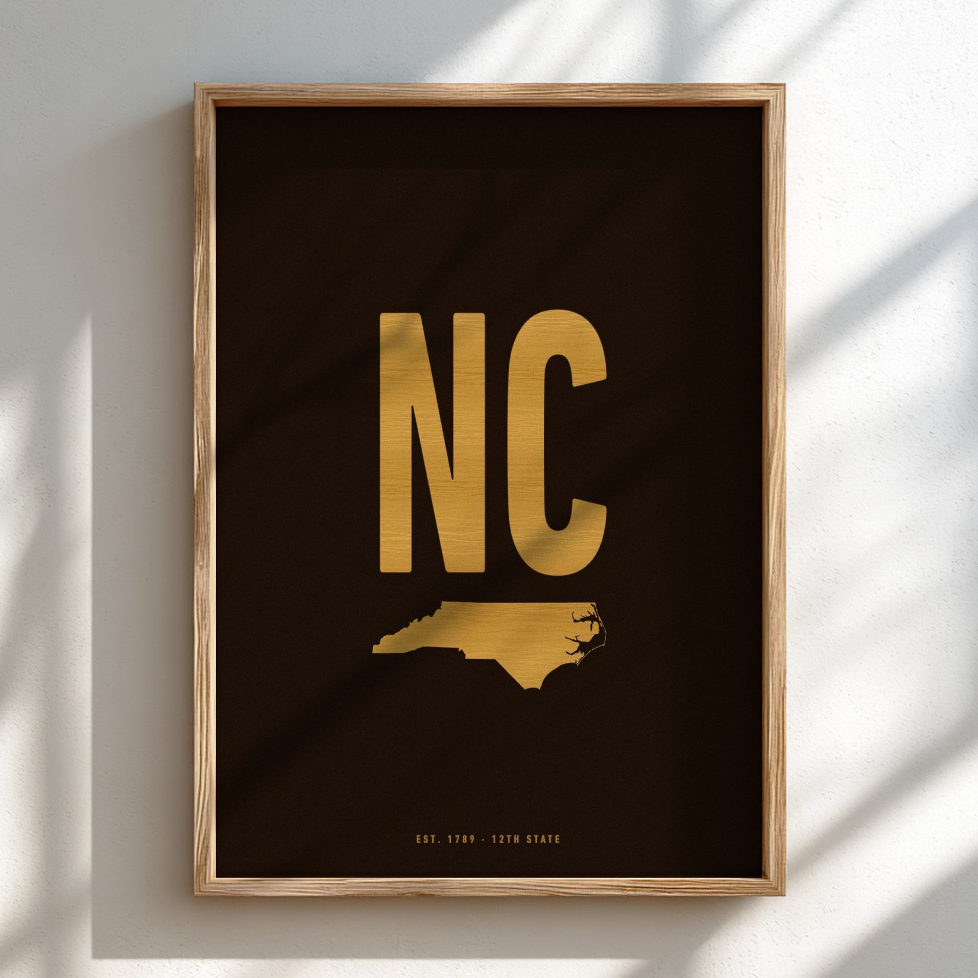 Framed artwork with 'NC' in gold on a black background
