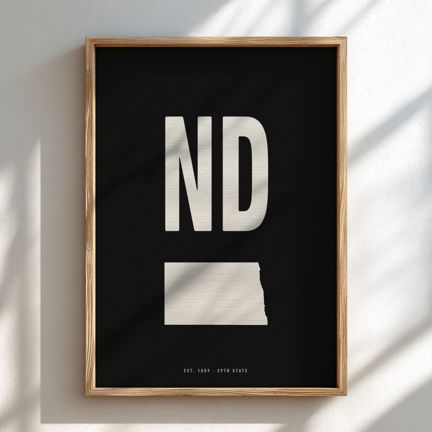 Framed poster with 'ND' and outline of North Dakota on a black background