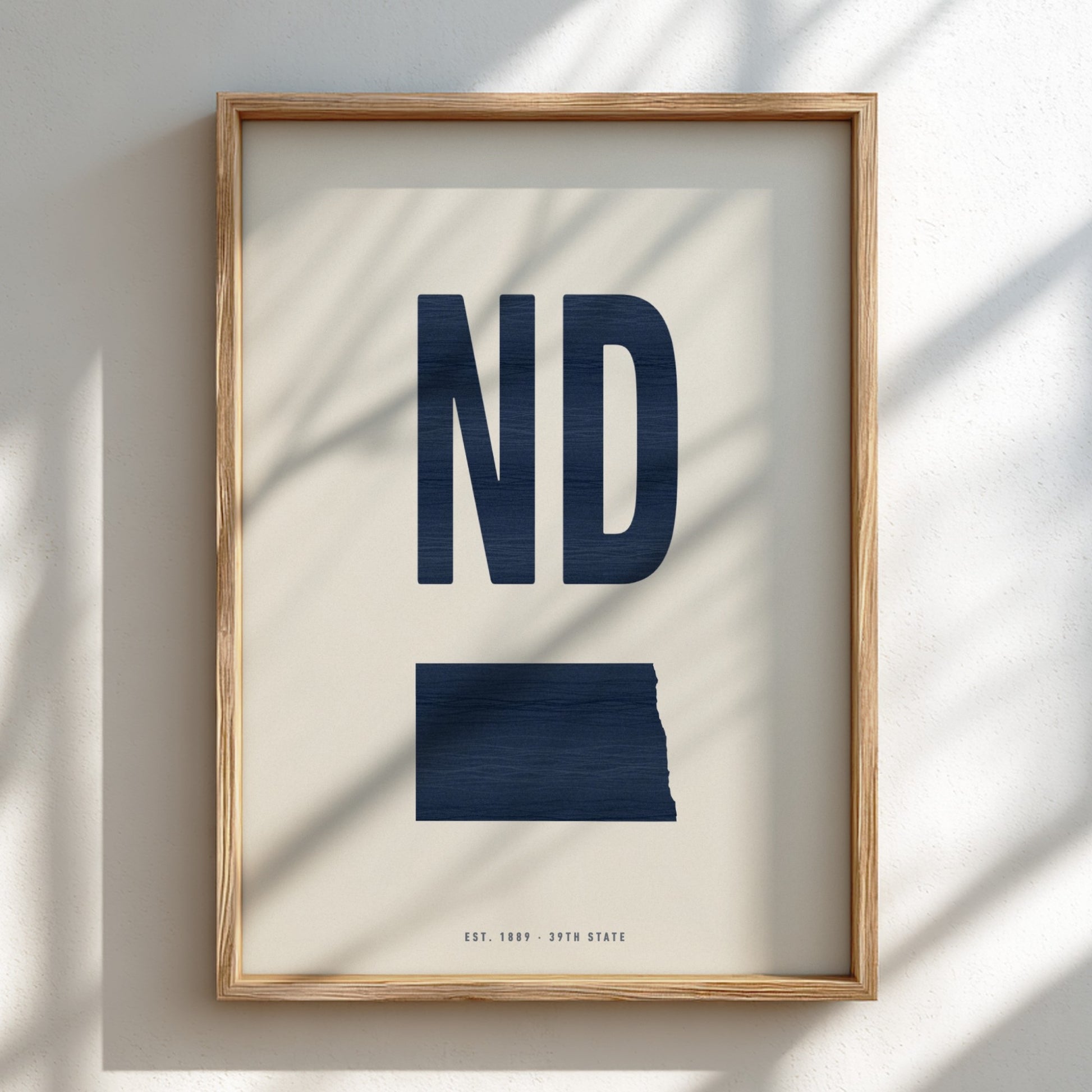 Framed artwork with 'ND' in navy on a light background