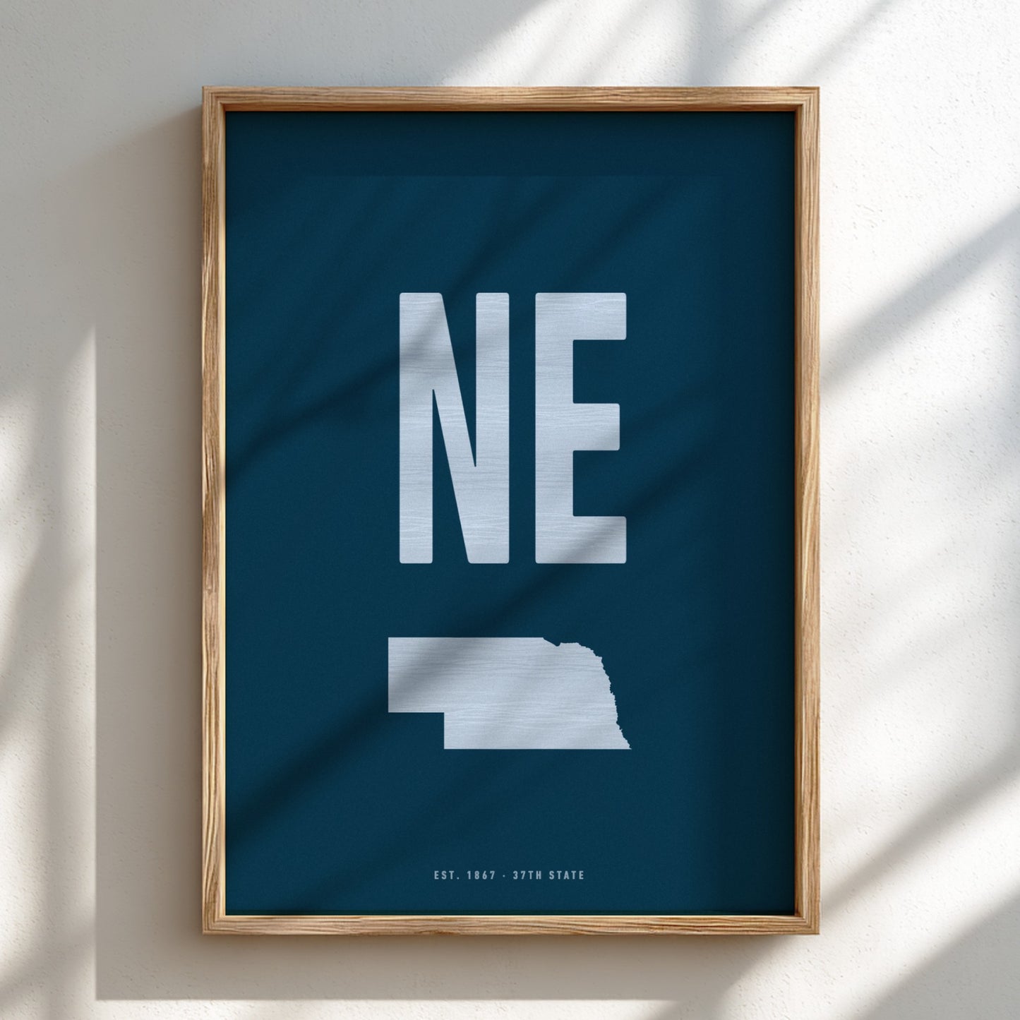 Framed poster with 'NE' and outline of Nebraska on a blue background