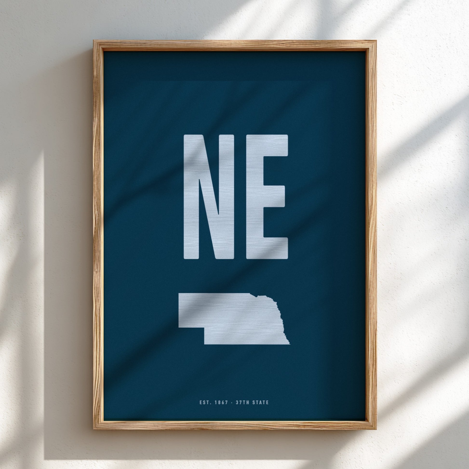 Framed poster with 'NE' and outline of Nebraska on a blue background