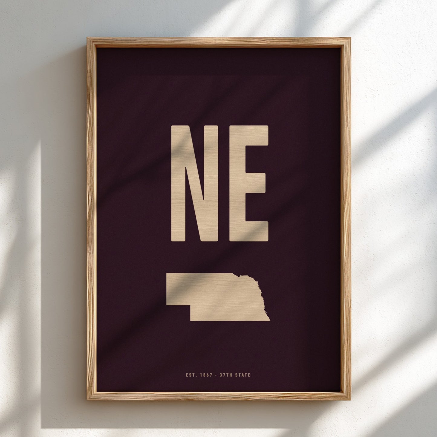 Framed poster with 'NE' and state outline on a dark background