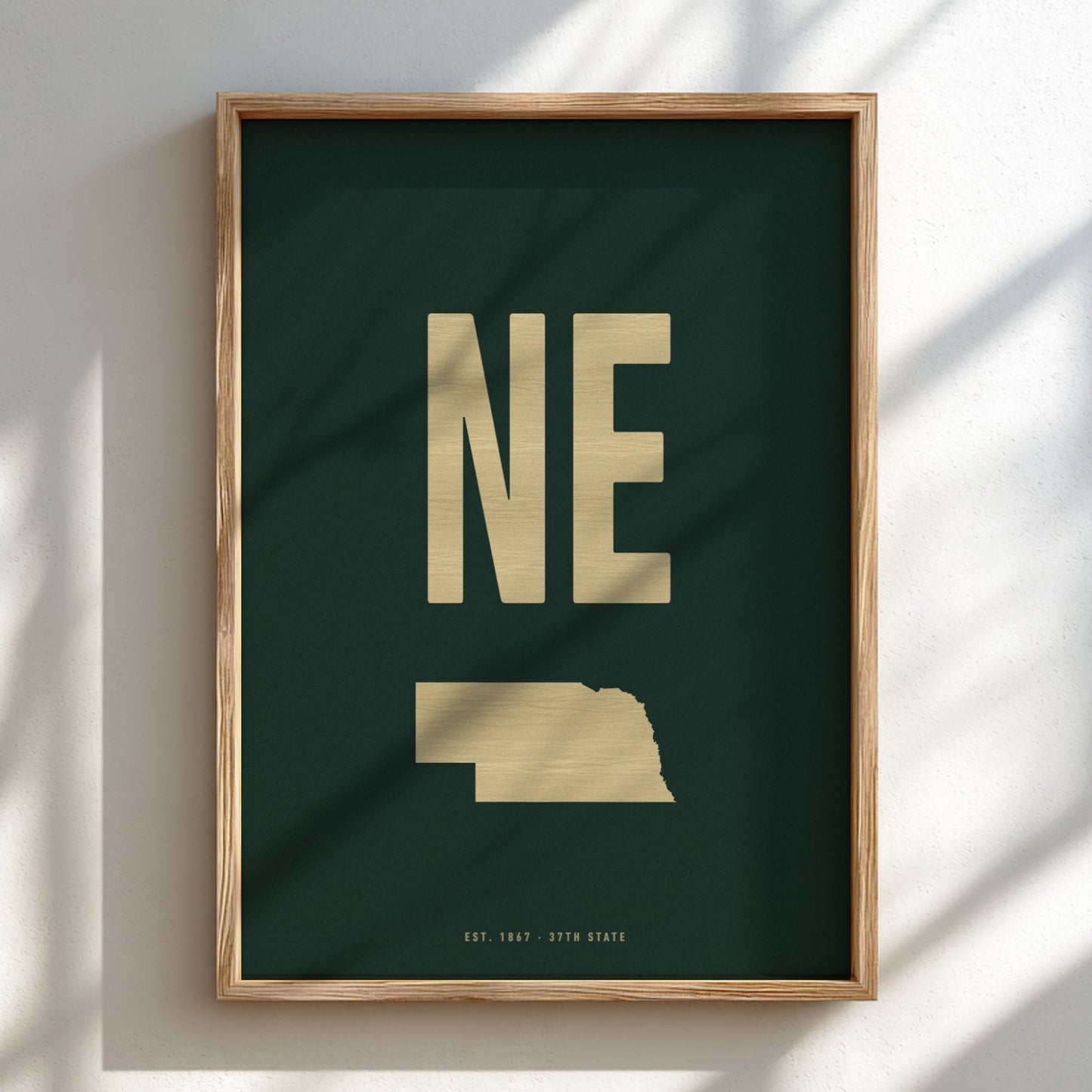 Framed artwork with 'NE' and a map of Nebraska on a dark green background
